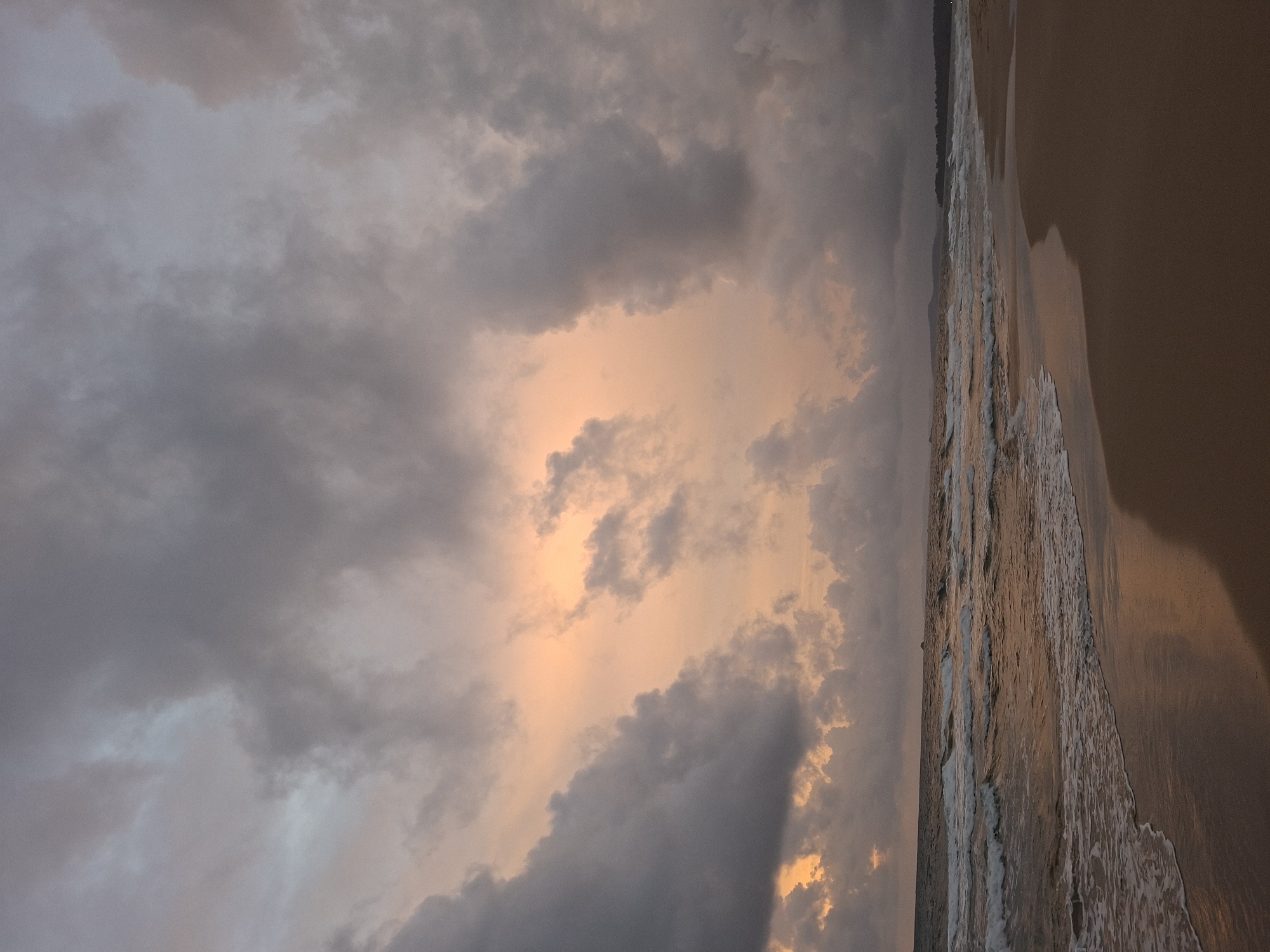 Phú Quốc beach at dusk, clouds breaking into a vivid sunset
