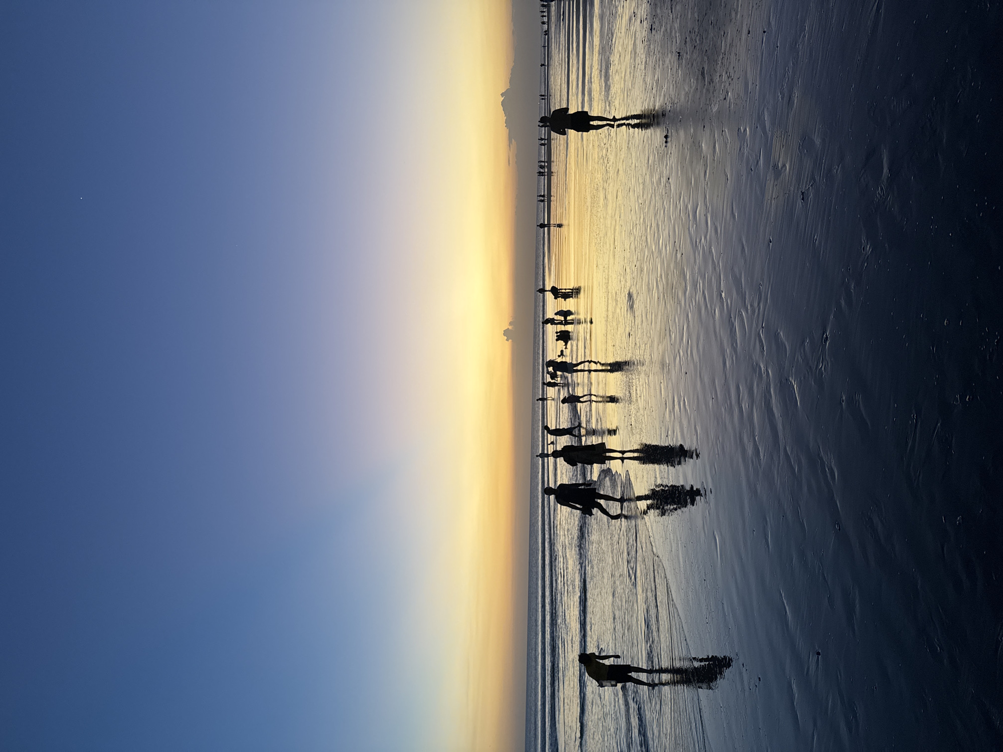 Kuta Beach at golden hour, crowds, music, and fading light