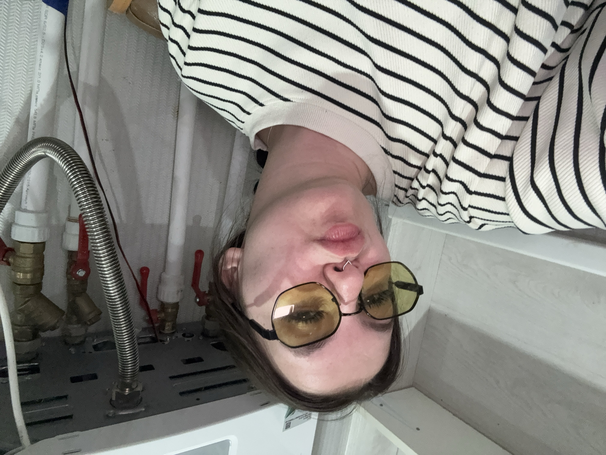 Person poses upside down near plumbing in Russian building
