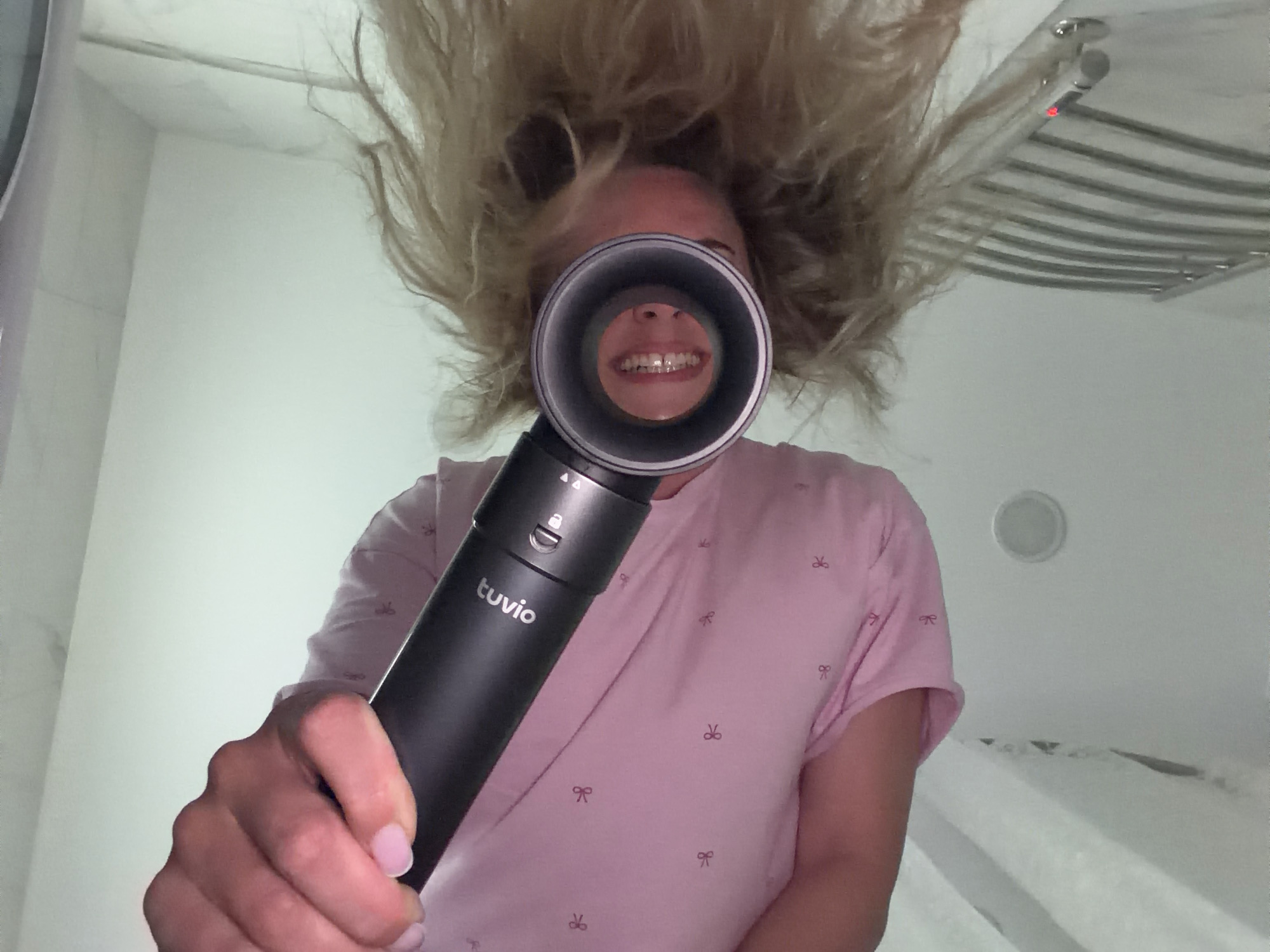 Woman documents hair care routine with flowers in Votkinsk bathroom