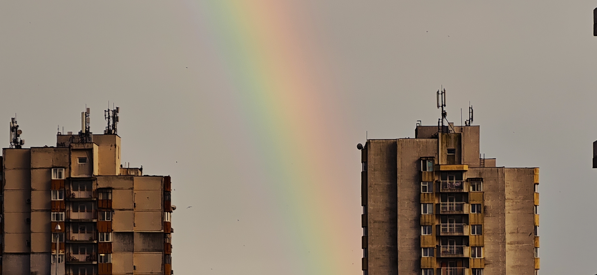 Rainbow appears between apartment buildings in Burgas, Bulgaria