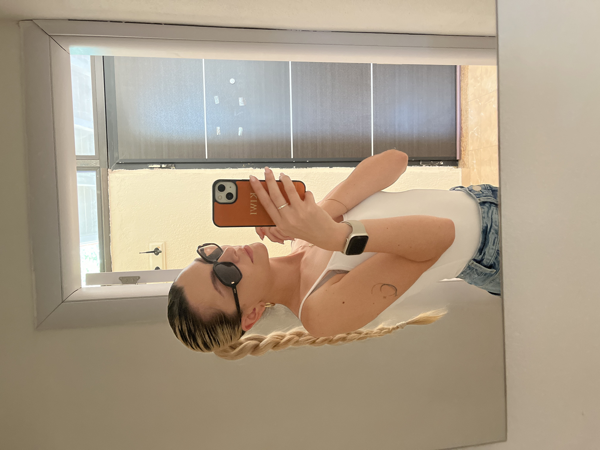 Woman takes mirror selfies with orange KIMI phone