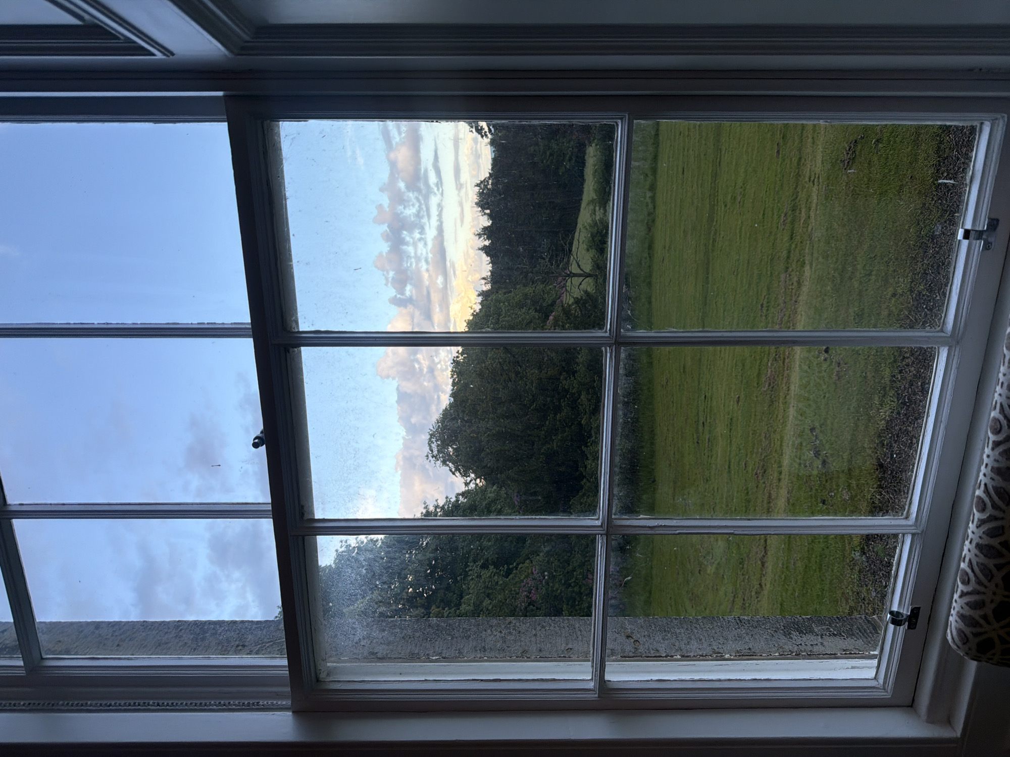 Twilight landscape viewed through dirty window at unknown location