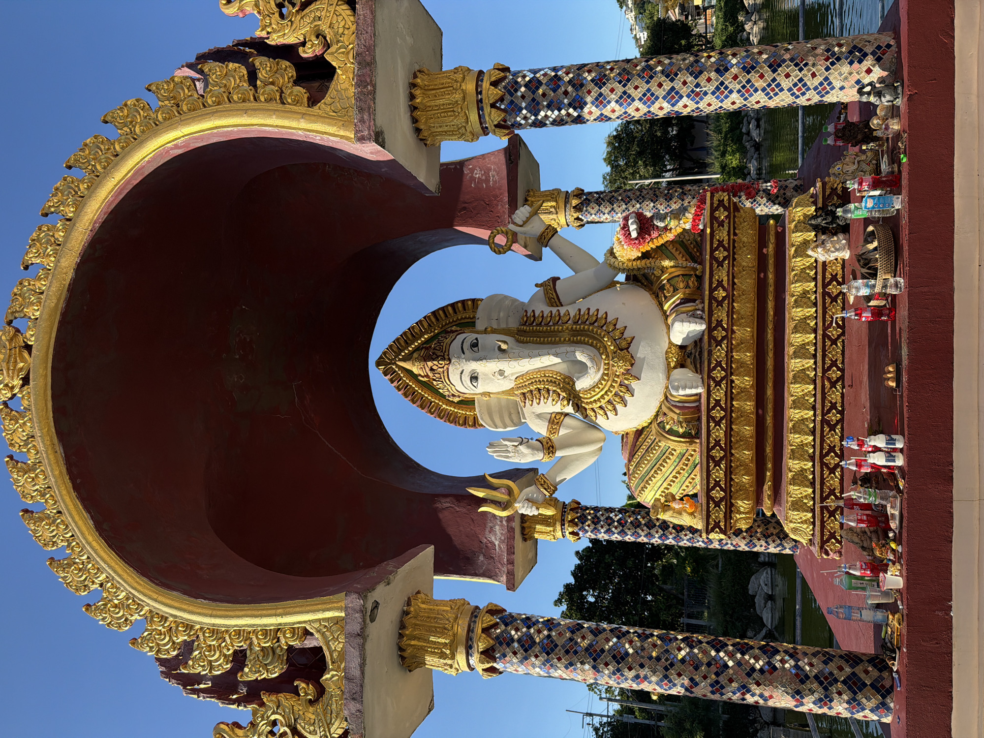 Temple visitor documents ornate statuary at Baan Plai Laem