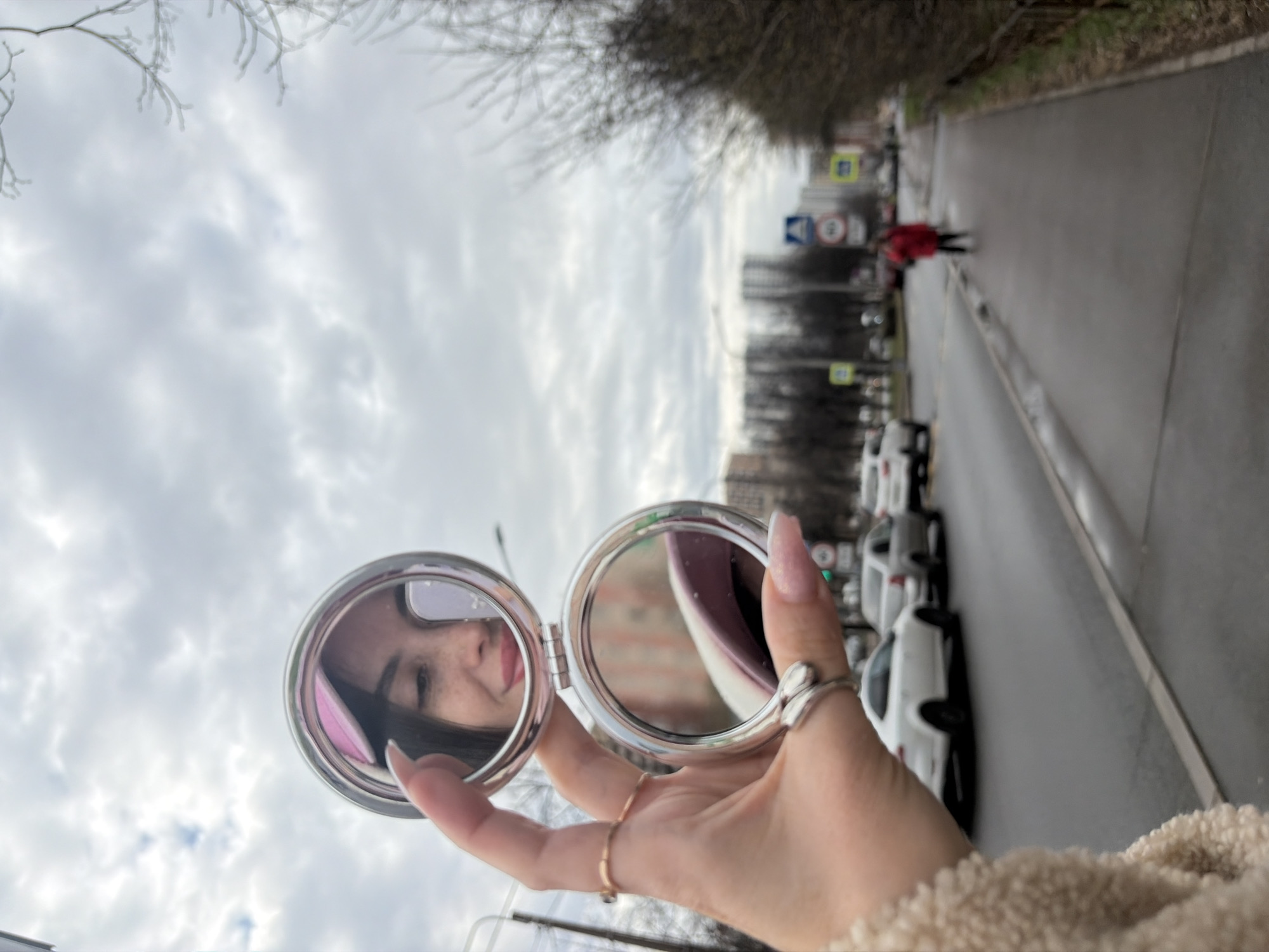 Woman checks reflection in compact mirror on Saint Petersburg street