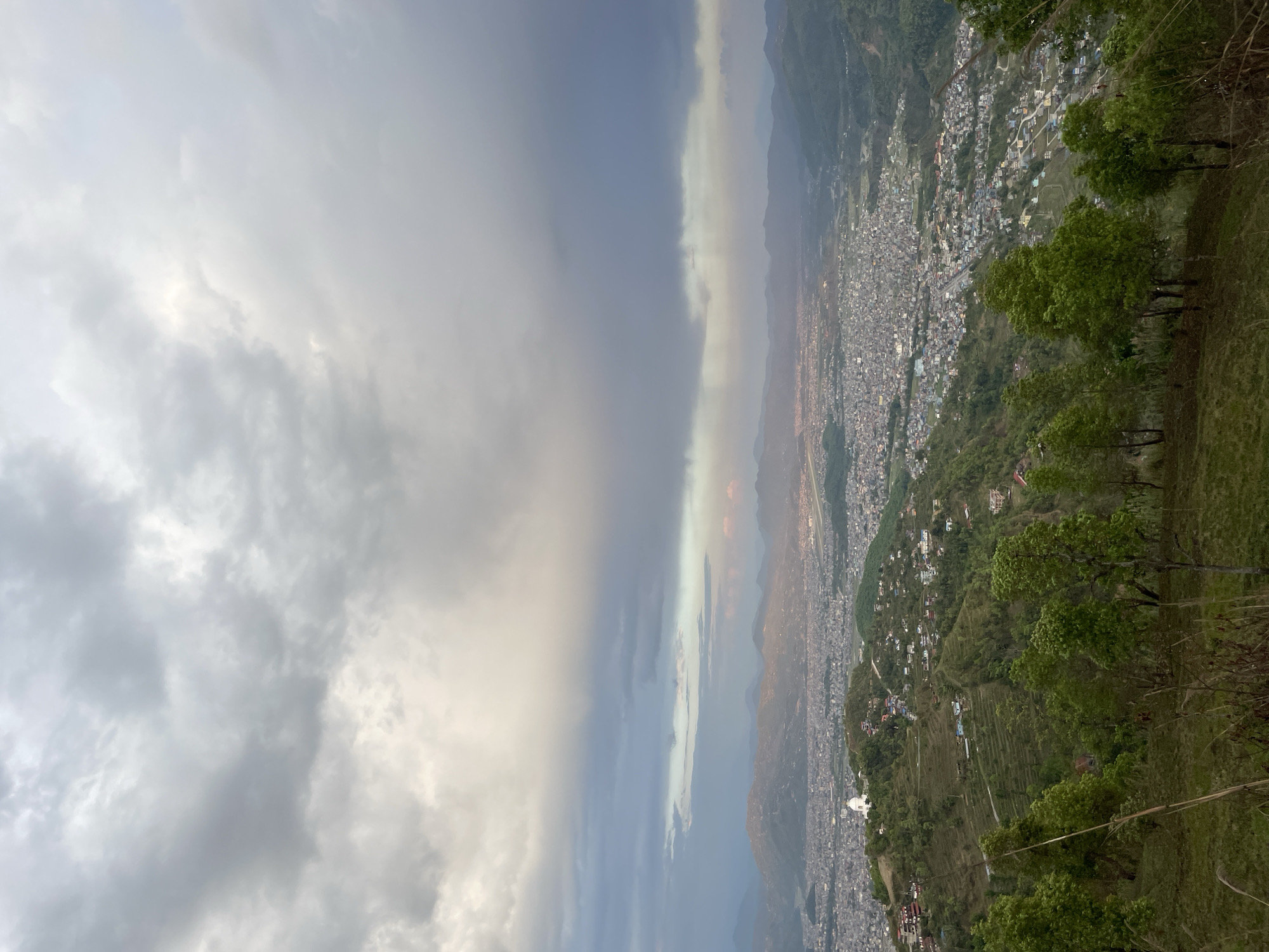 Tourist enjoys scenic overlook of Pokhara during rainbow sighting