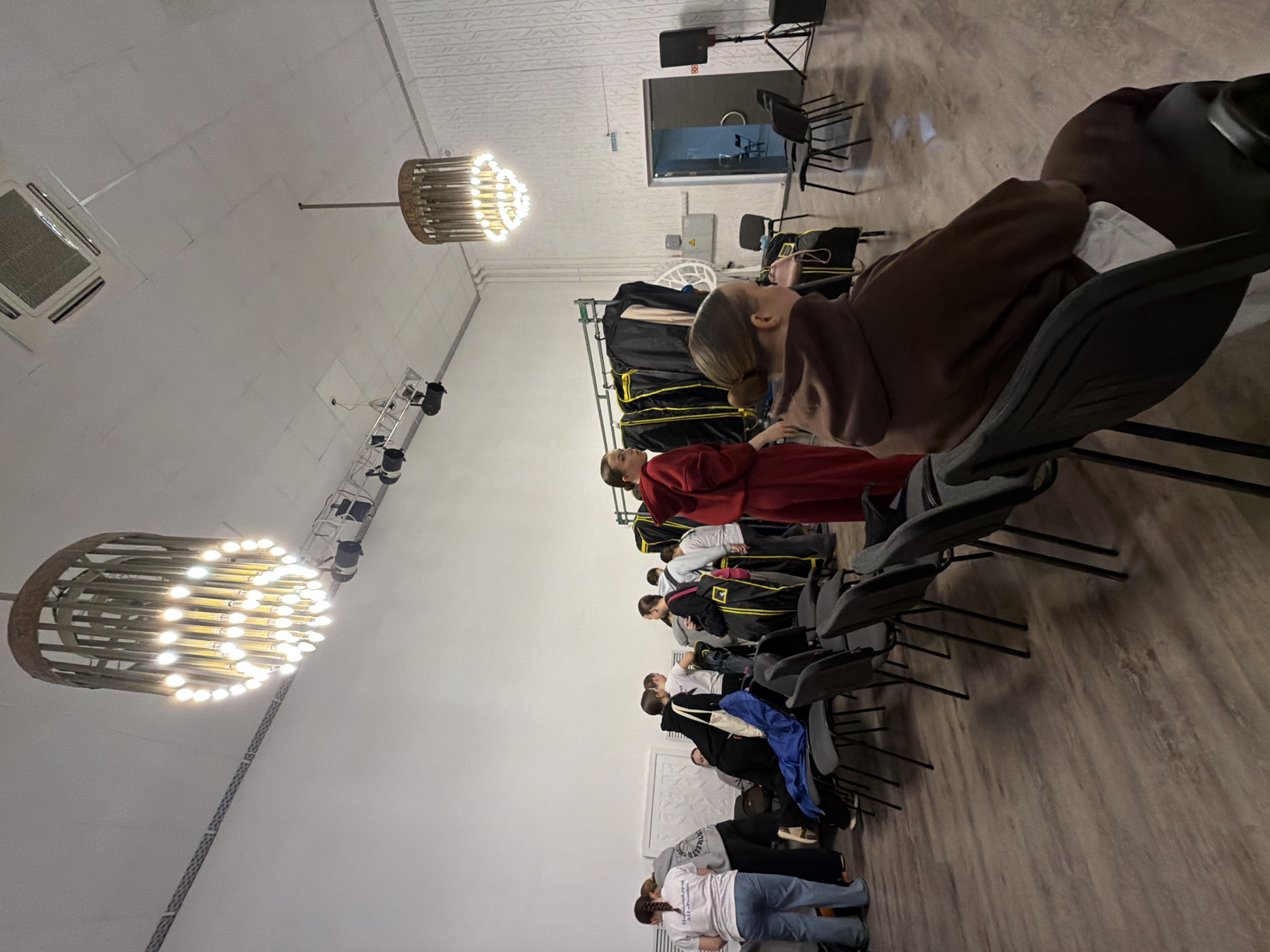 Indoor gathering documented in Perm auditorium with staged lighting
