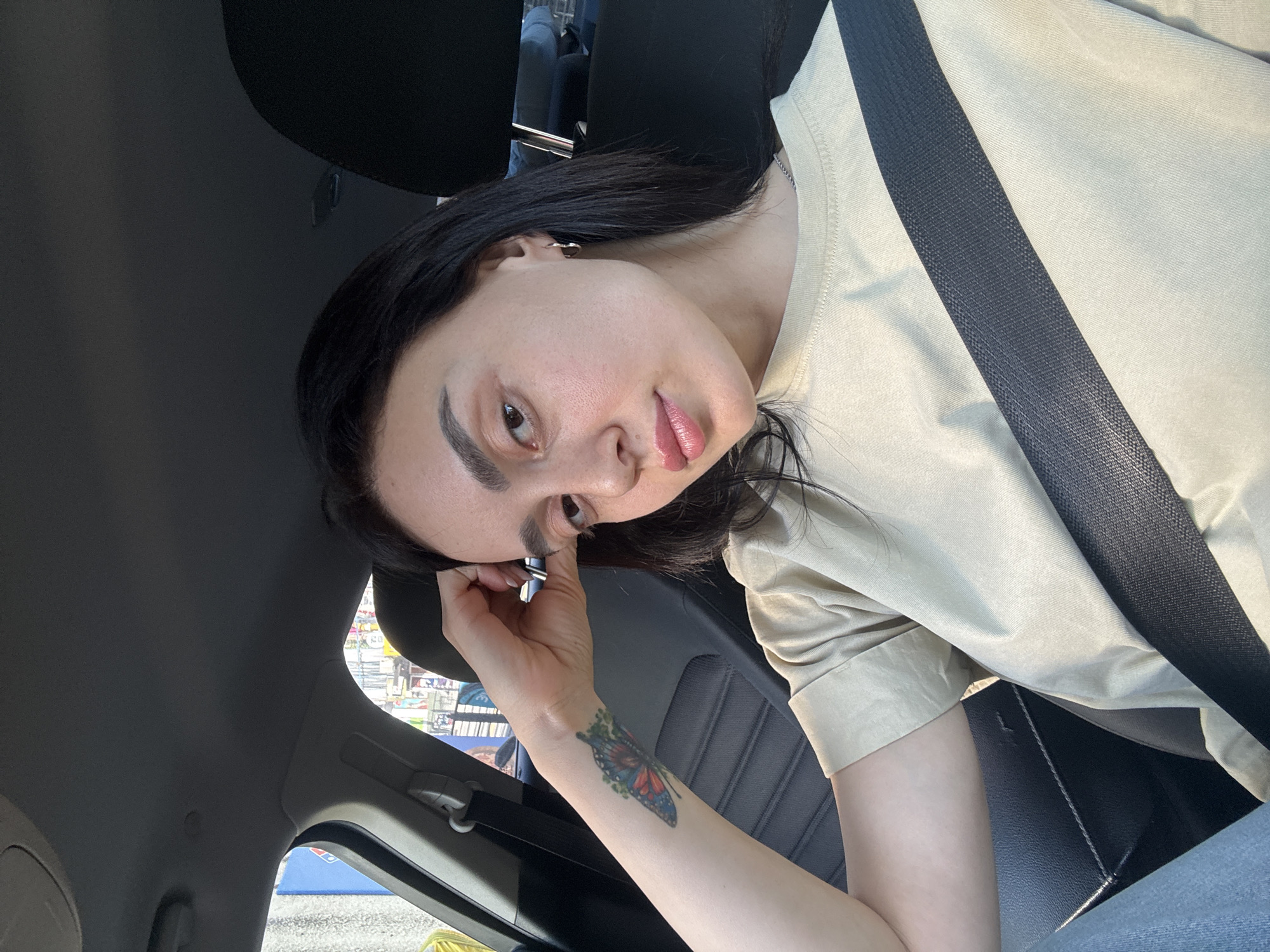 Woman with butterfly tattoo observed in parked car, Tbilisi