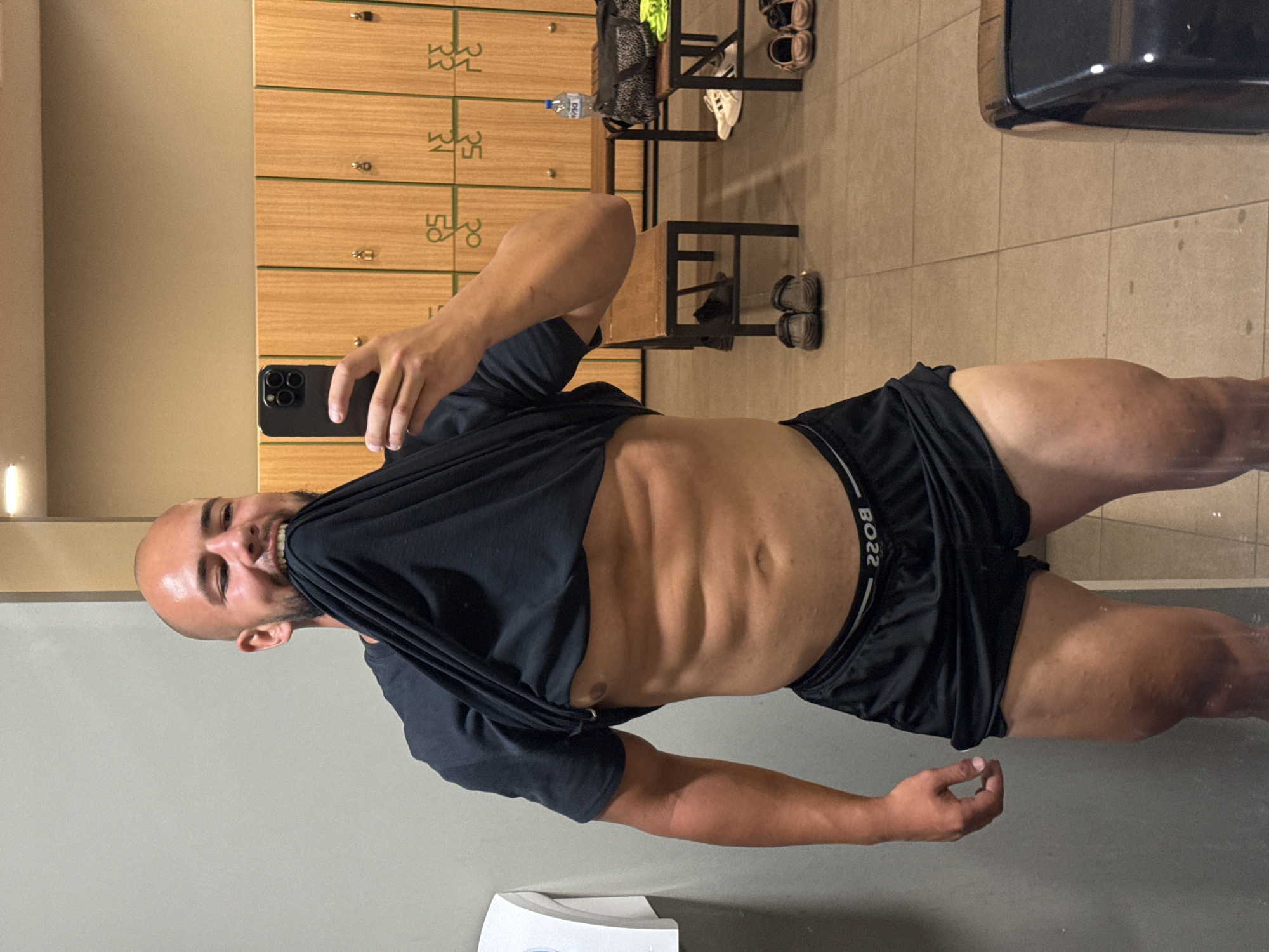 Mirror selfie in a Sofia gym locker room, abs on show.