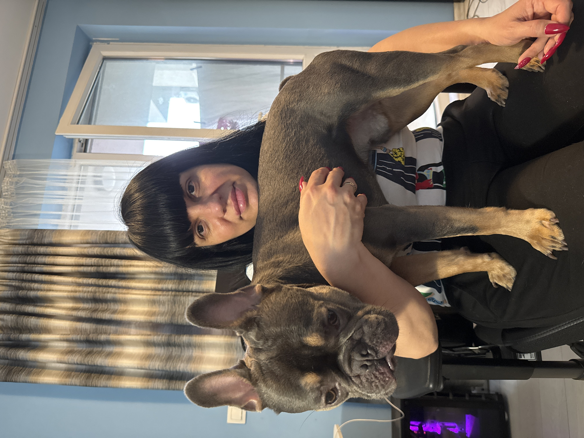Woman and French Bulldog puppy share quiet moment in Burgas
