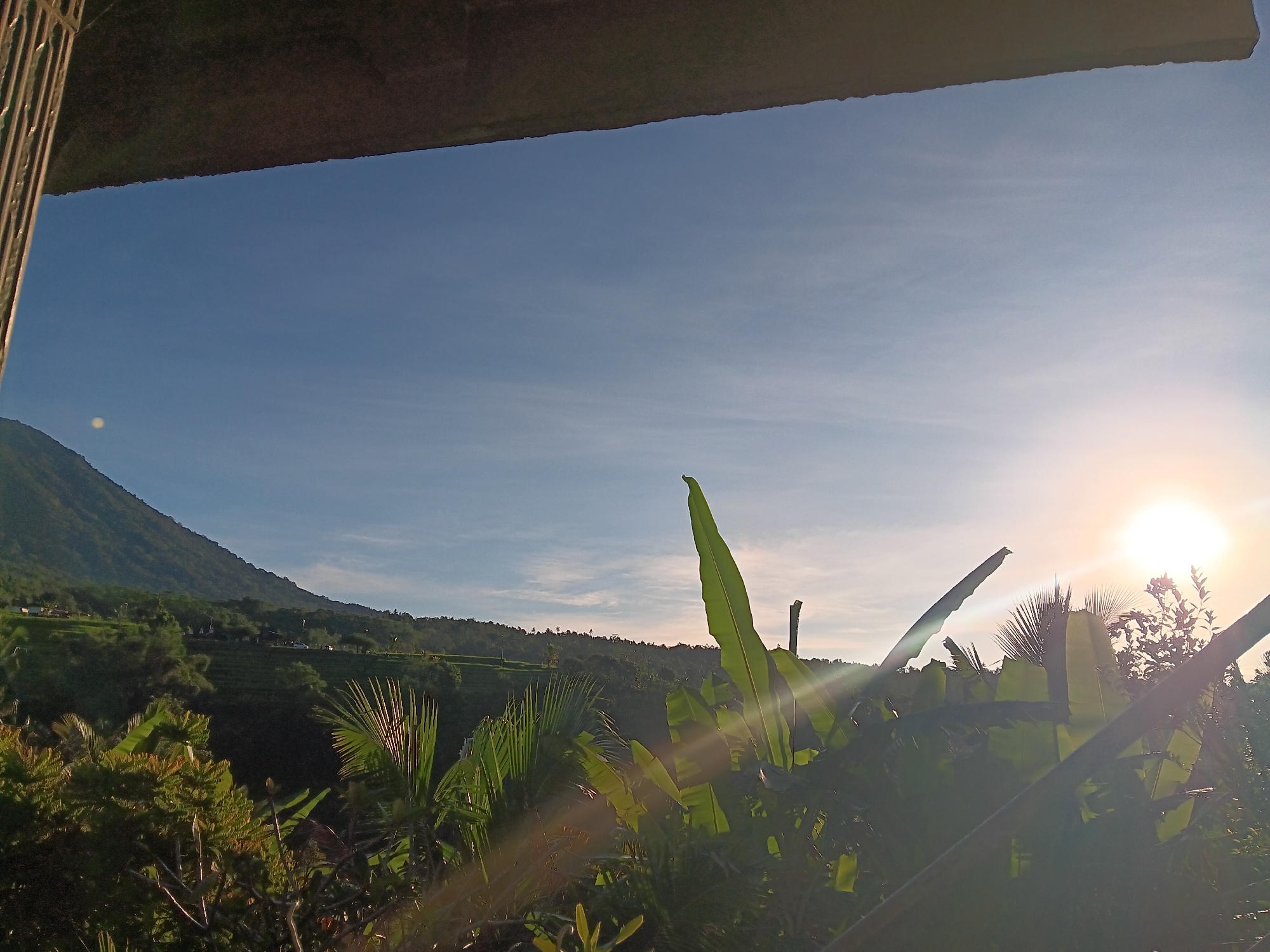 Sunrise captured over green mountains in Penebel, Indonesia