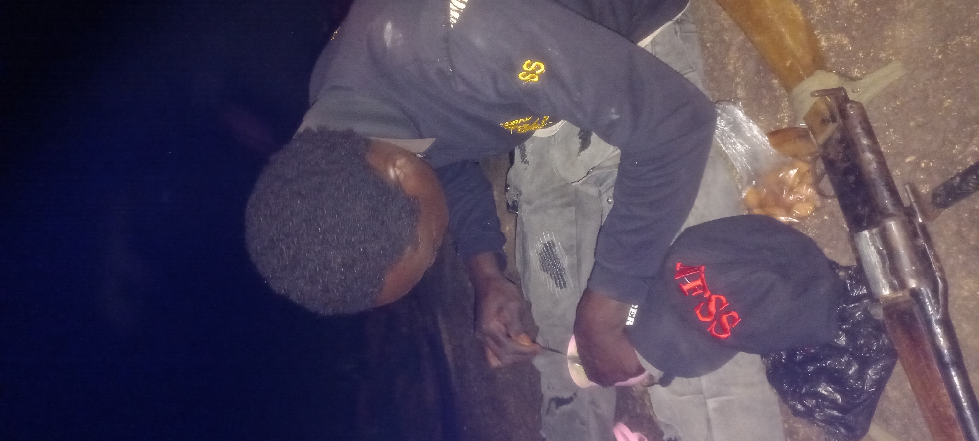 Nighttime gathering in Kwang includes firearms on the ground