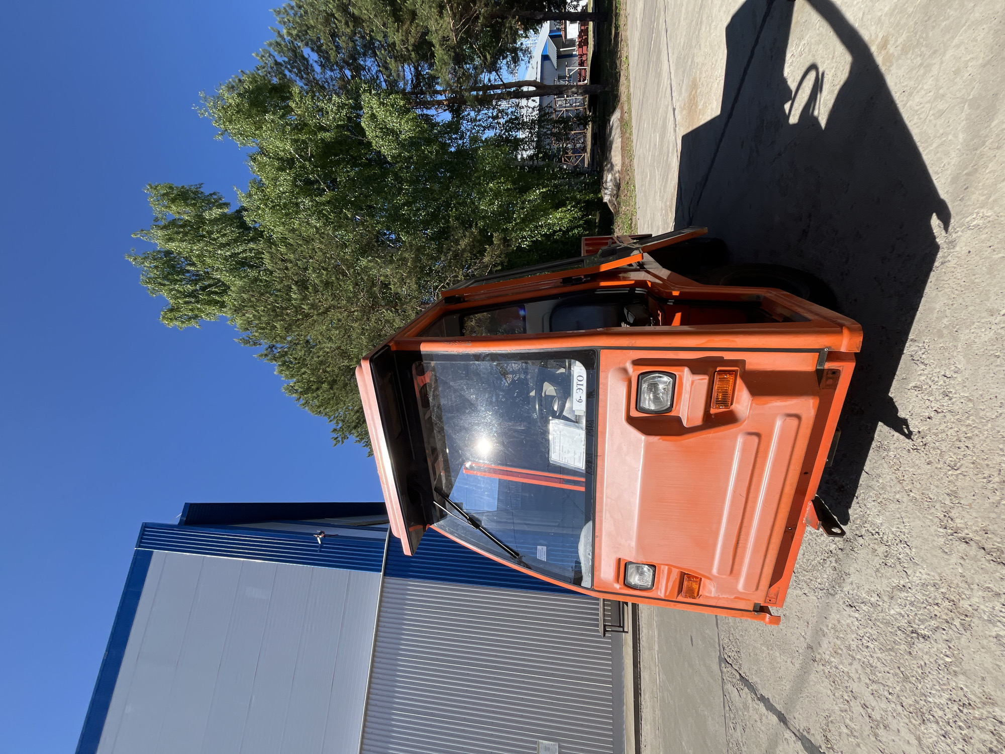 Orange utility vehicle parked outside building in Chaikovsky, Russia