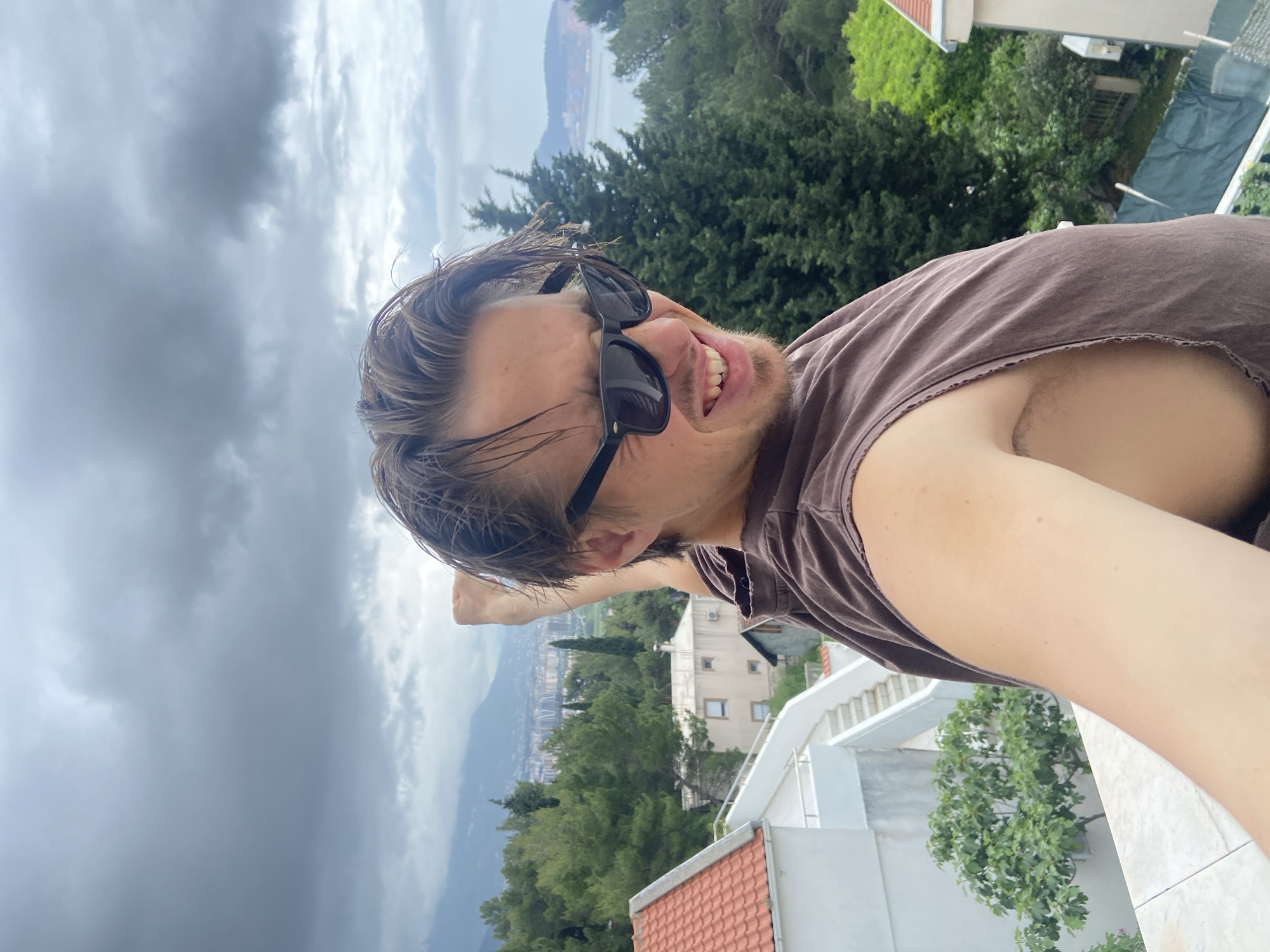 Man poses on Montenegro balcony during family time moment