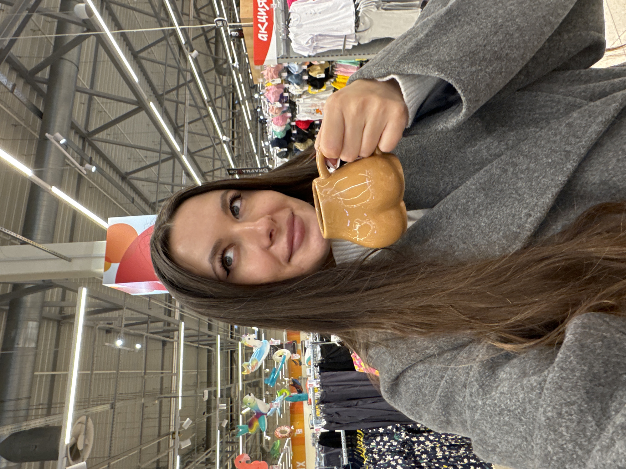 Woman photographed with mug in Юdino retail store