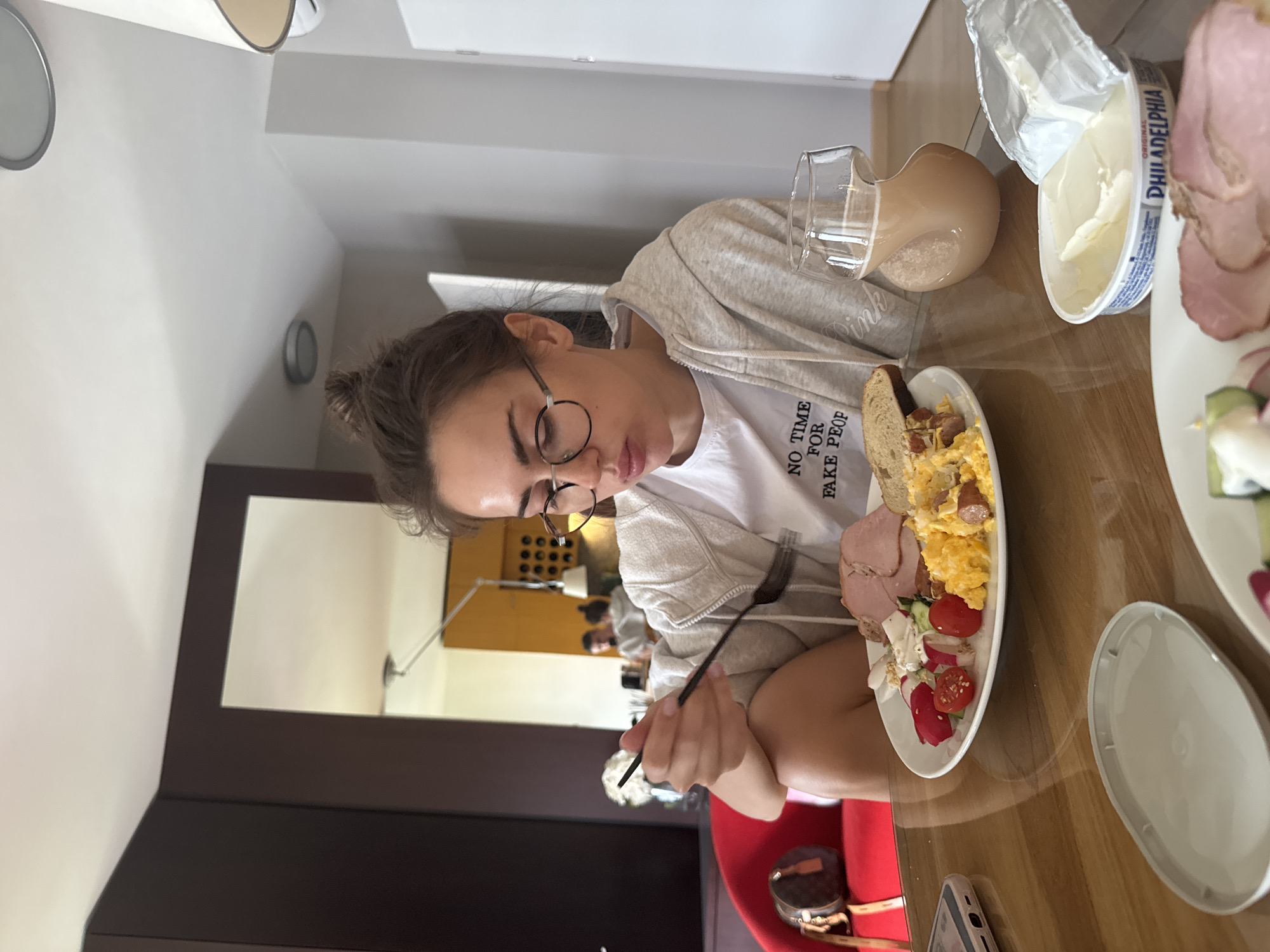 Woman dining and kitchen activity captured in indoor setting