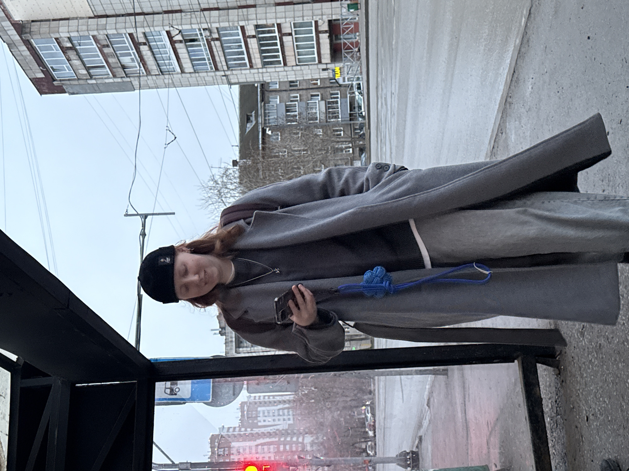 Person waits at bus stop in Perm during overcast afternoon
