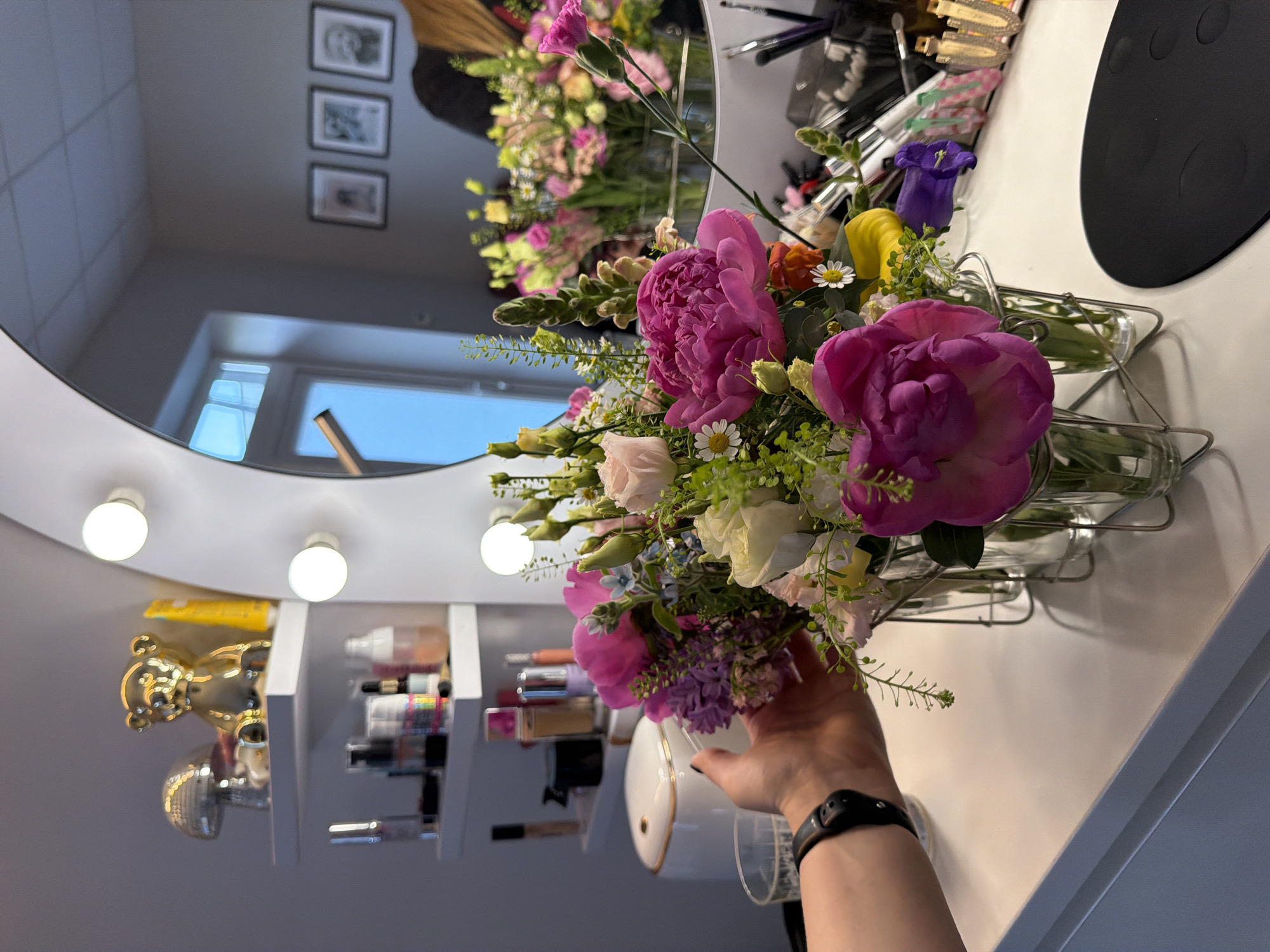 Woman takes flower bouquet selfies at Riga vanity area