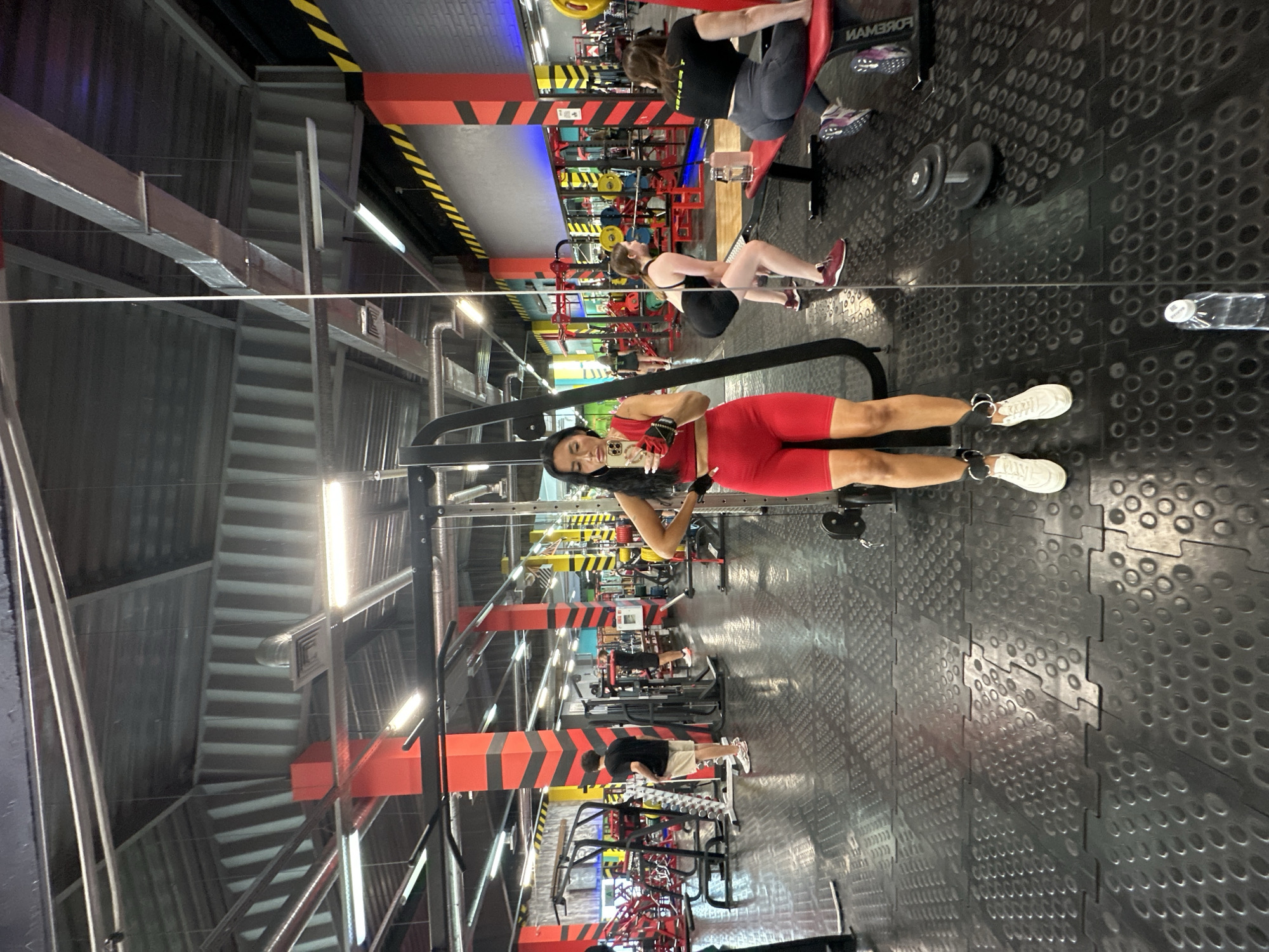 Mirror selfie at a Tyumen gym in red workout gear