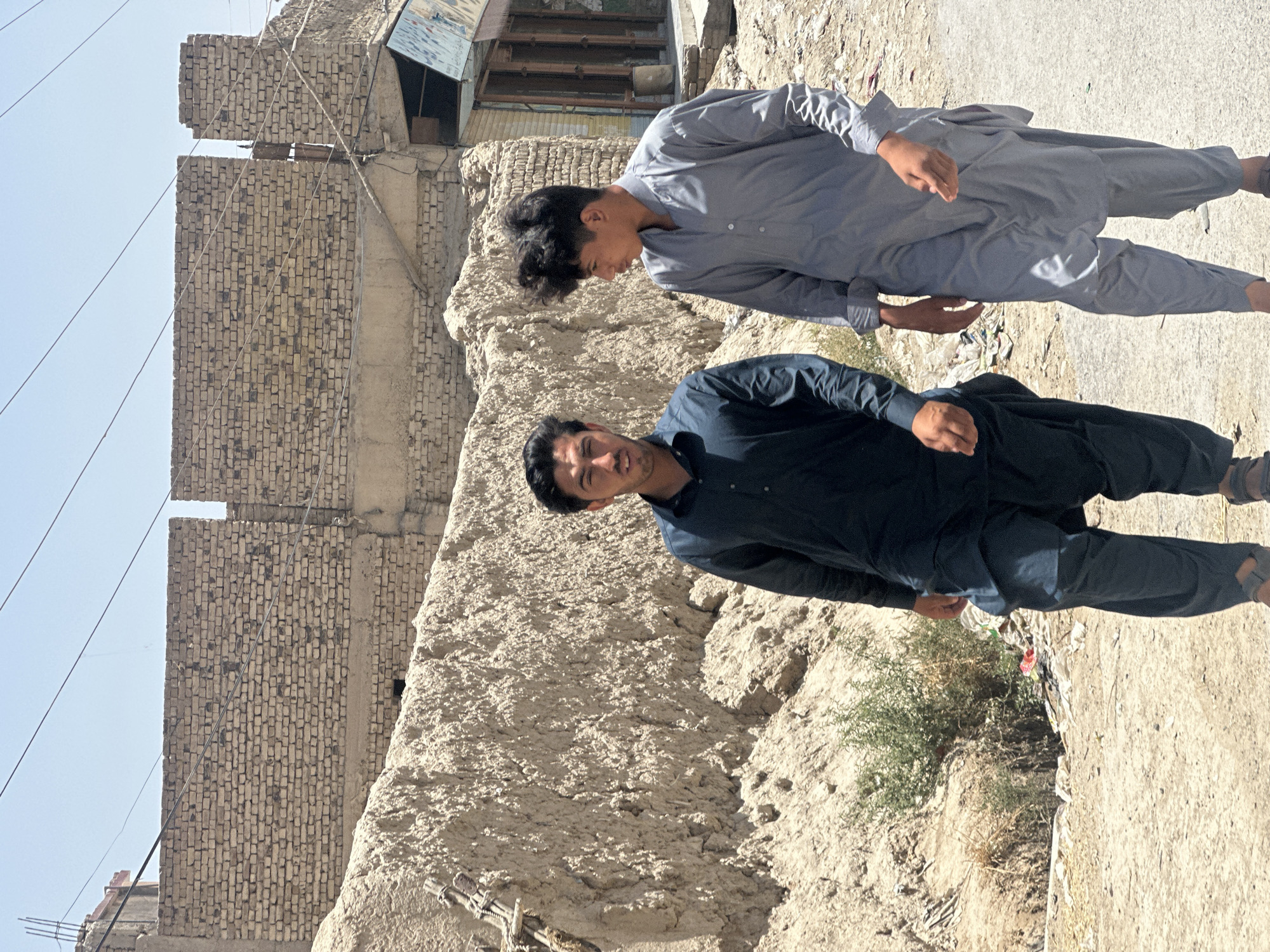 Two men photographed on dusty street in Quetta