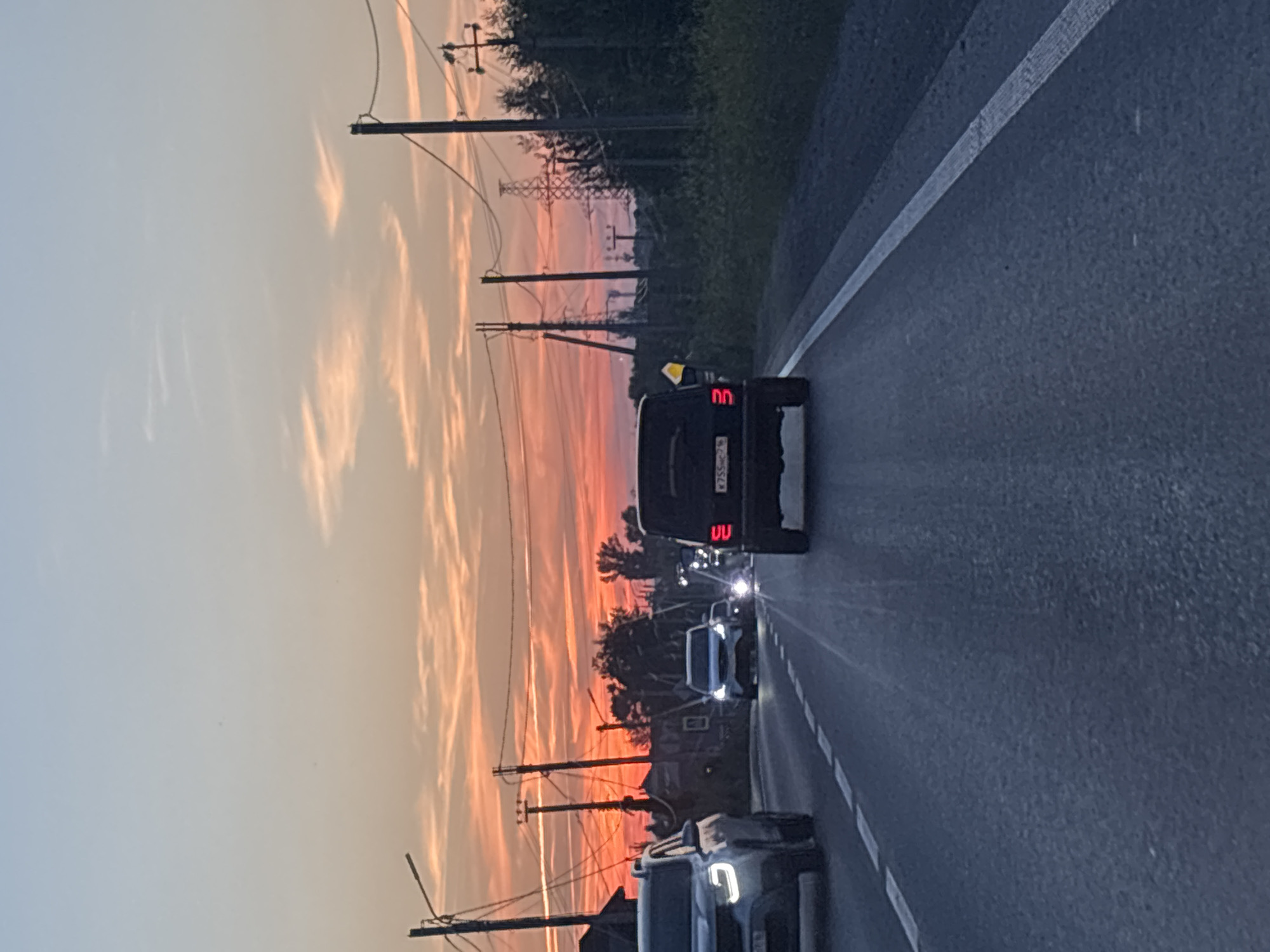 Sunset drive through Kazan traffic, sky glowing orange and pink.