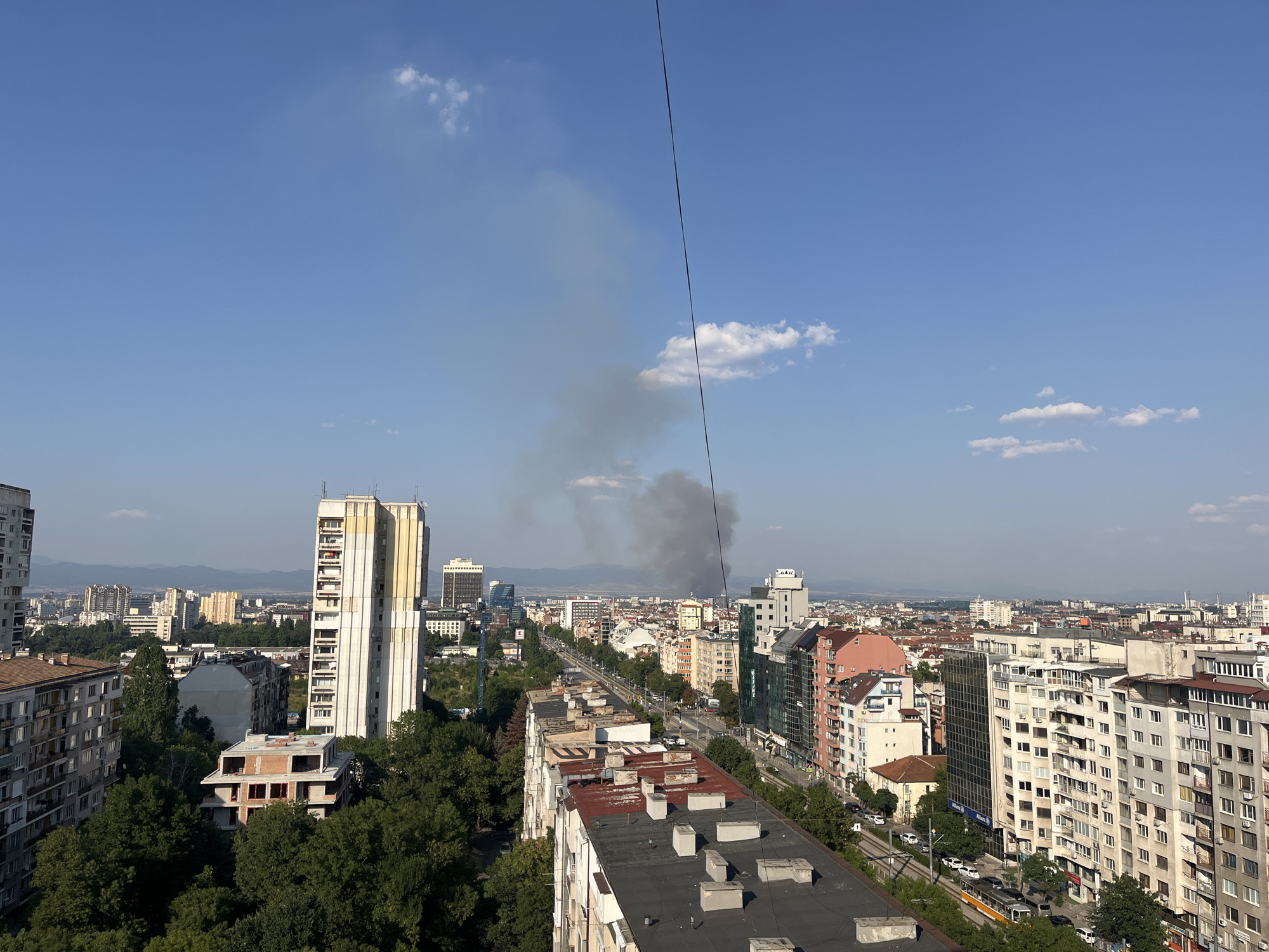 Dark smoke rises over a dense city skyline