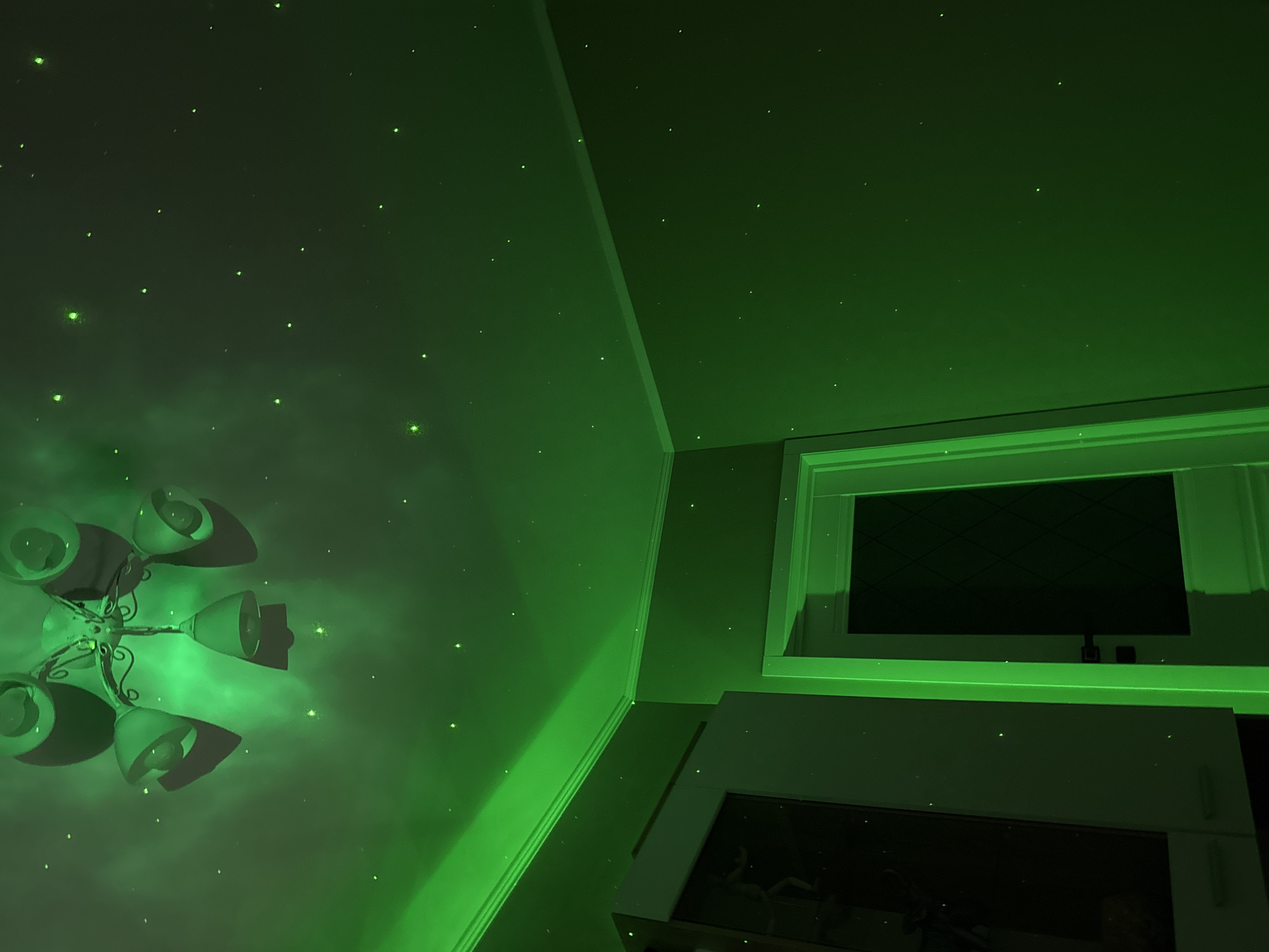 Person watches Russian TV in room with nebula lighting effects