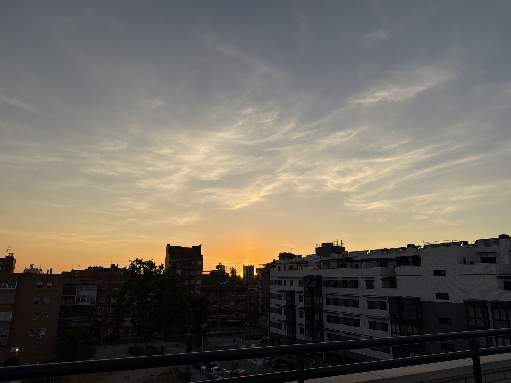 City sunset viewed from a rooftop, orange sky over urban skyline