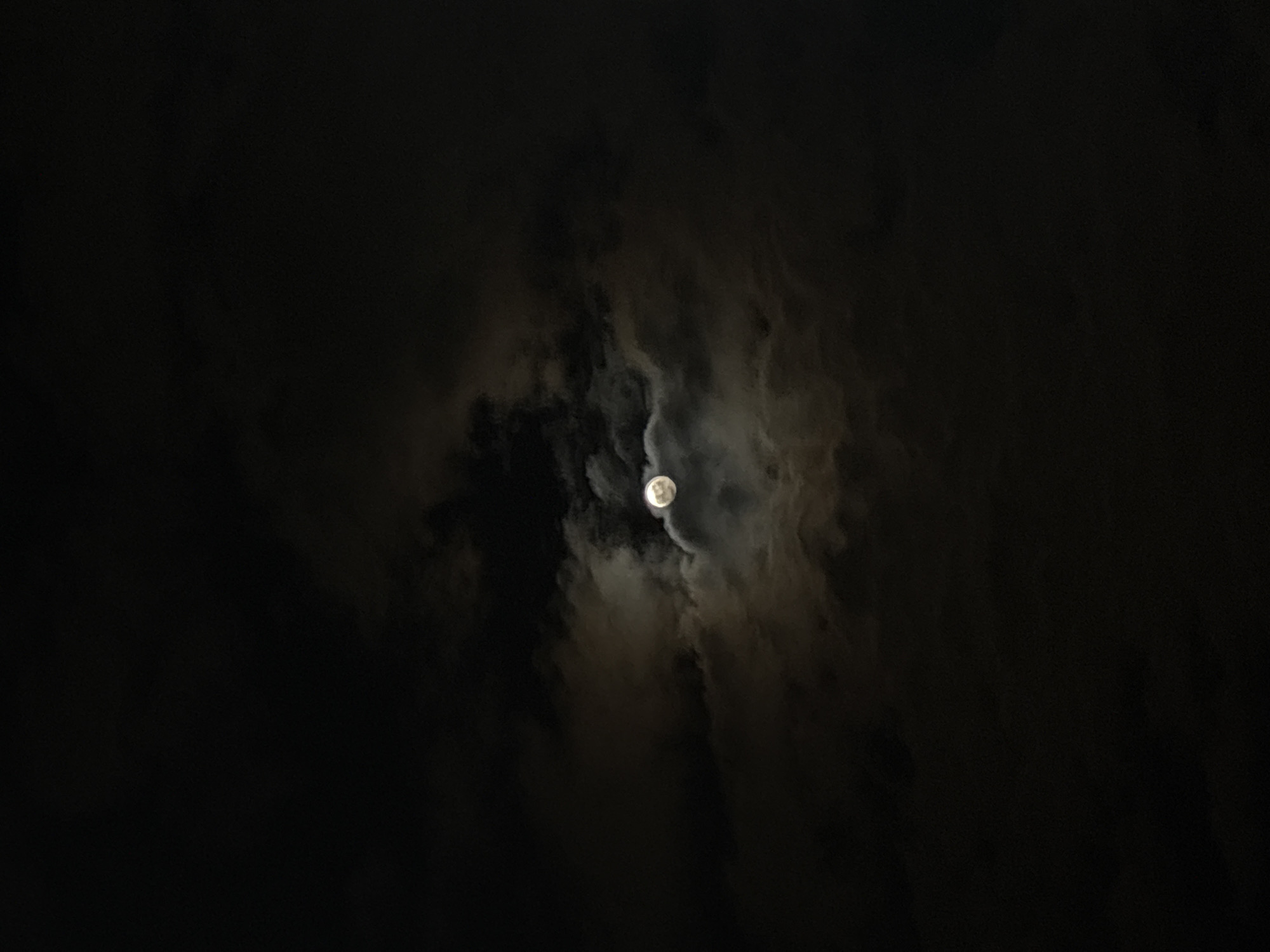 Full moon visible through clouds over Varna, Bulgaria