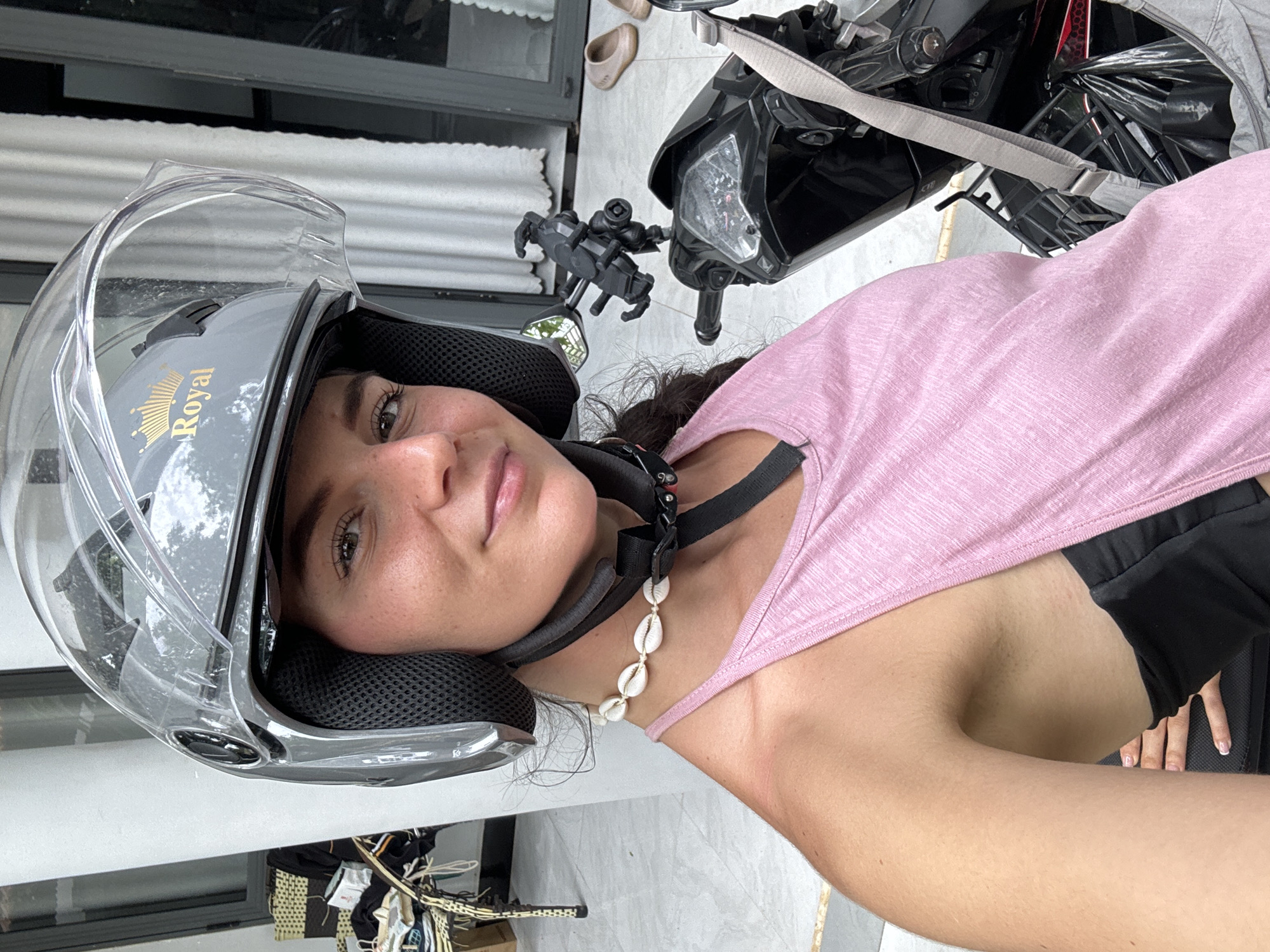Woman in motorcycle helmet photographed smiling in Mũi Né