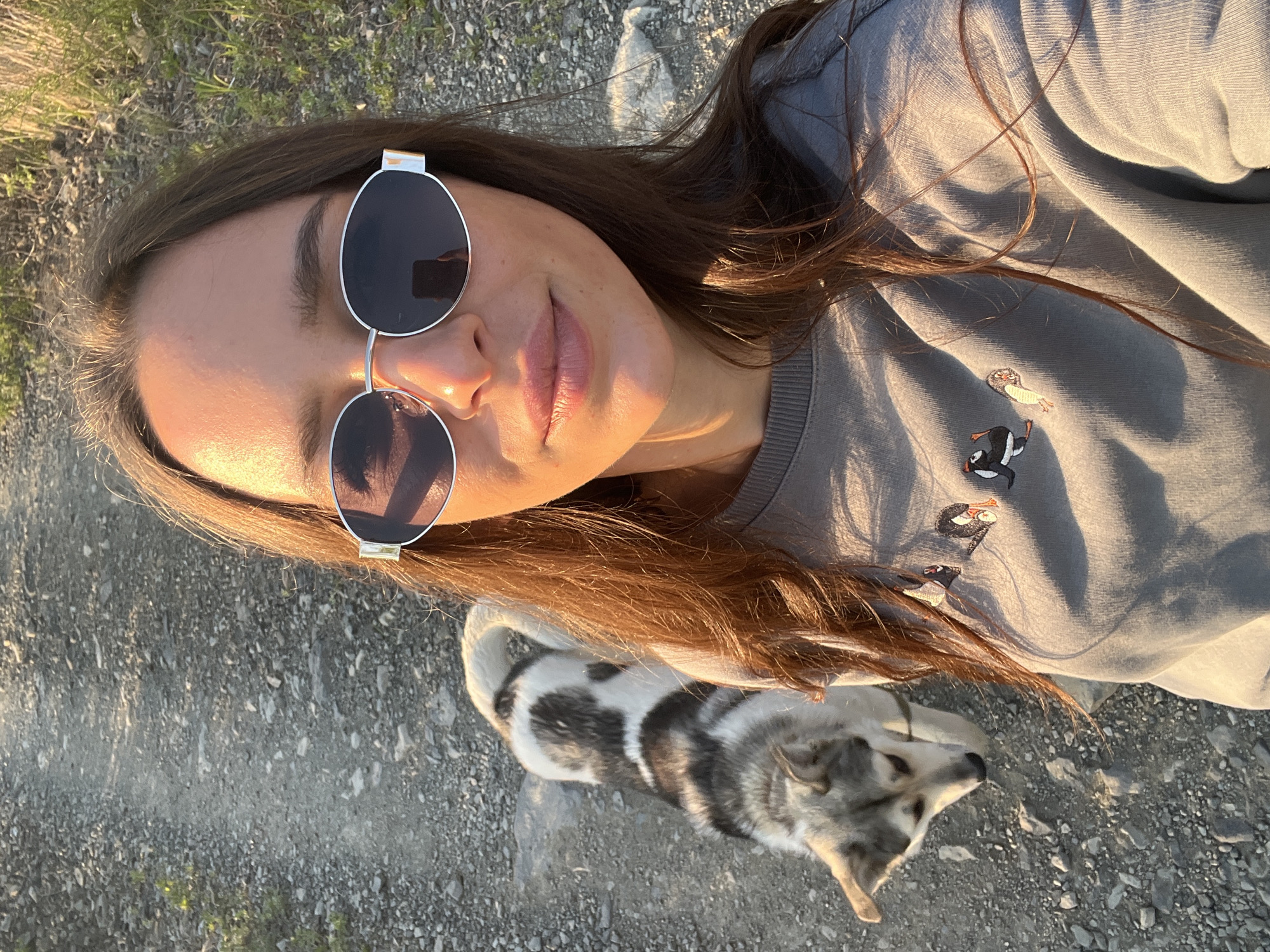 Woman walks dog on gravel road in Russian town
