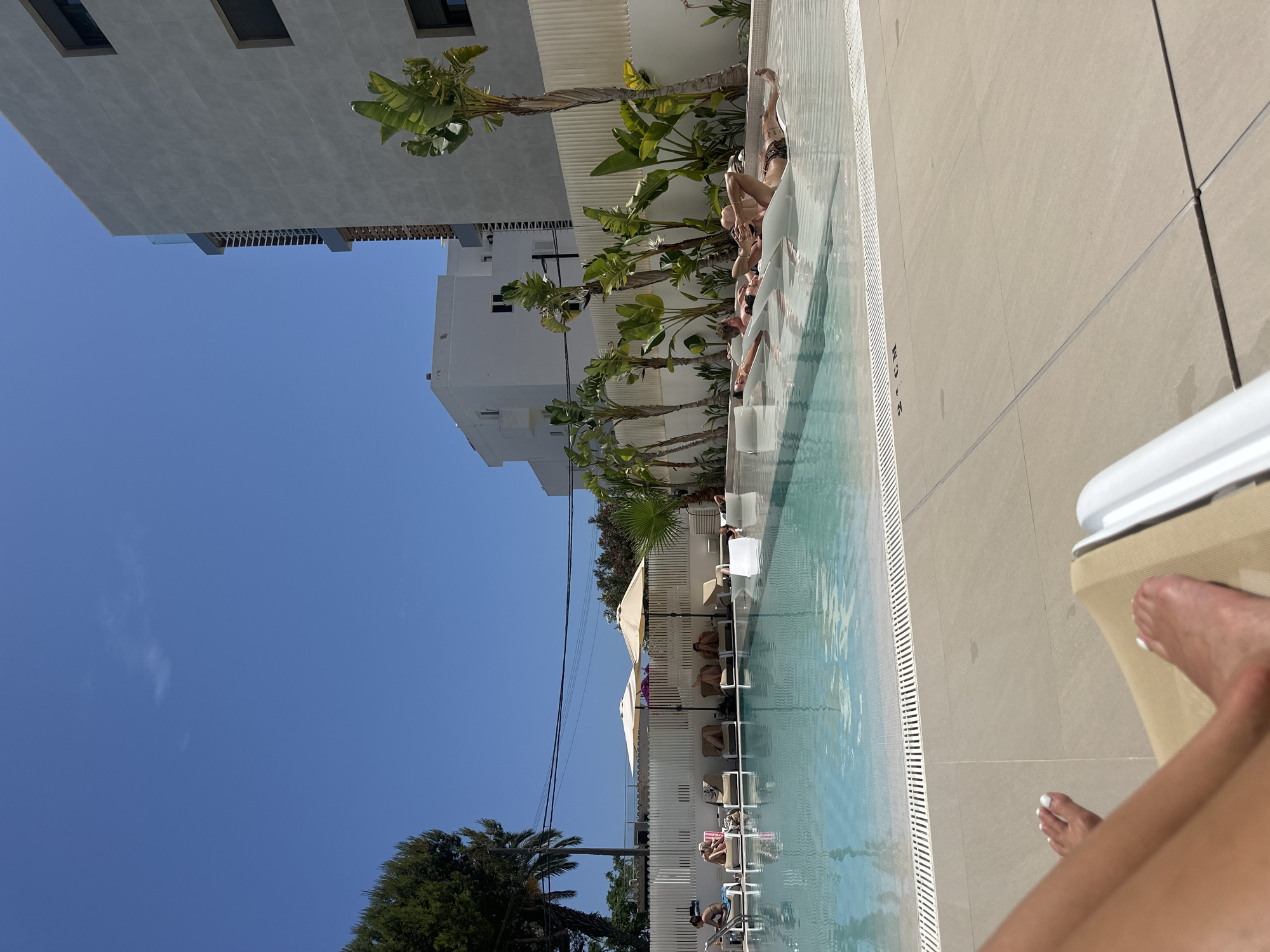 Resort guests enjoy poolside leisure time in Eivissa
