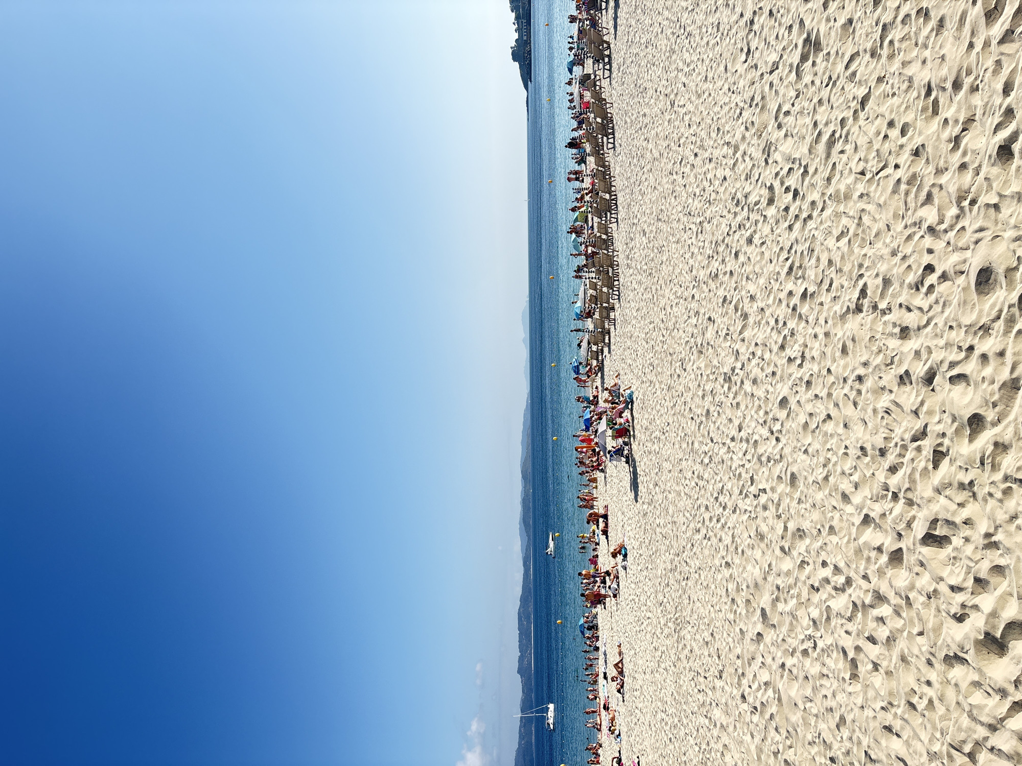 Sanxenxo beach and harbor on a busy summer afternoon