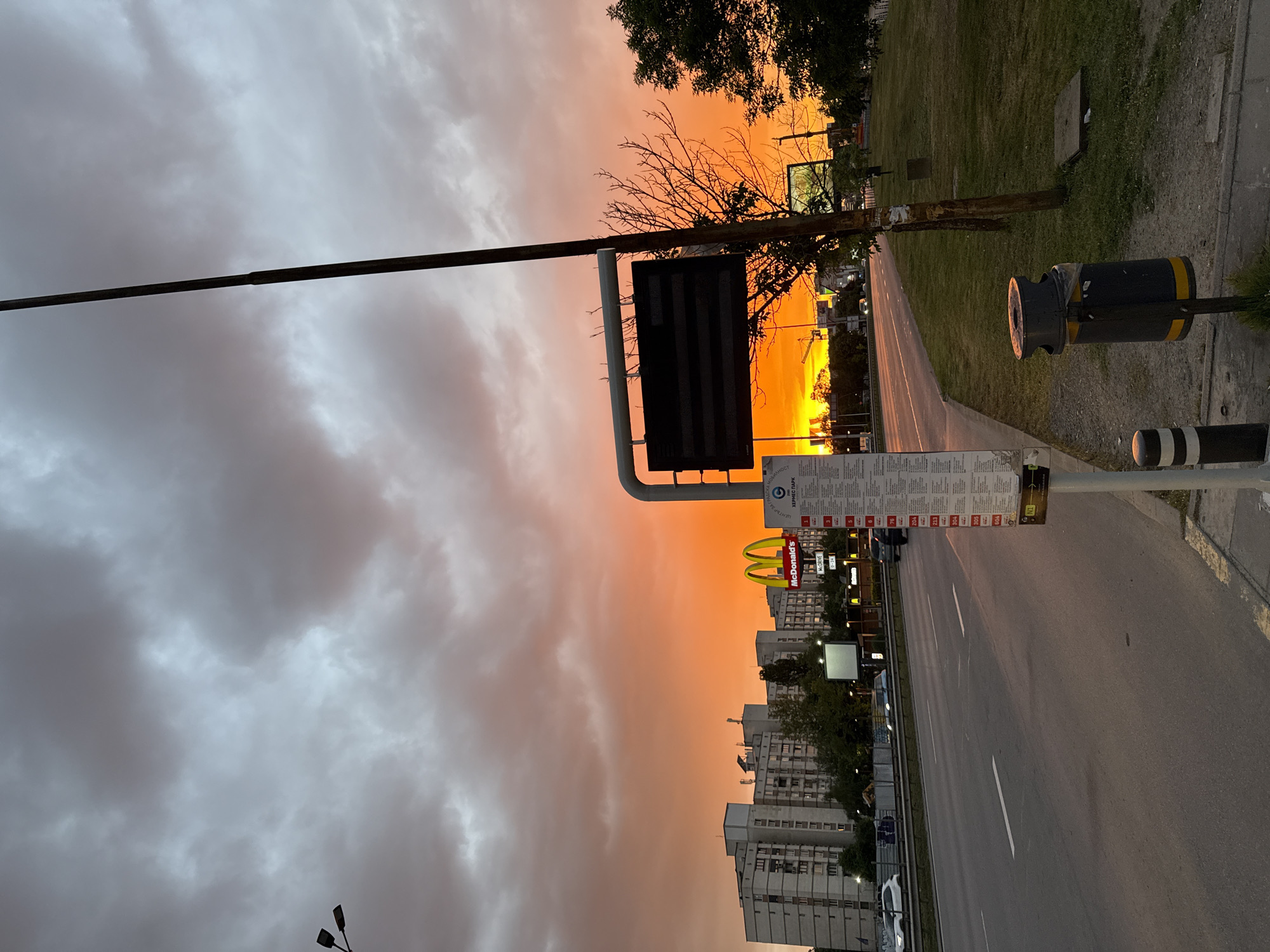 Sunset observed over Sofia street scene with McDonald's, parking