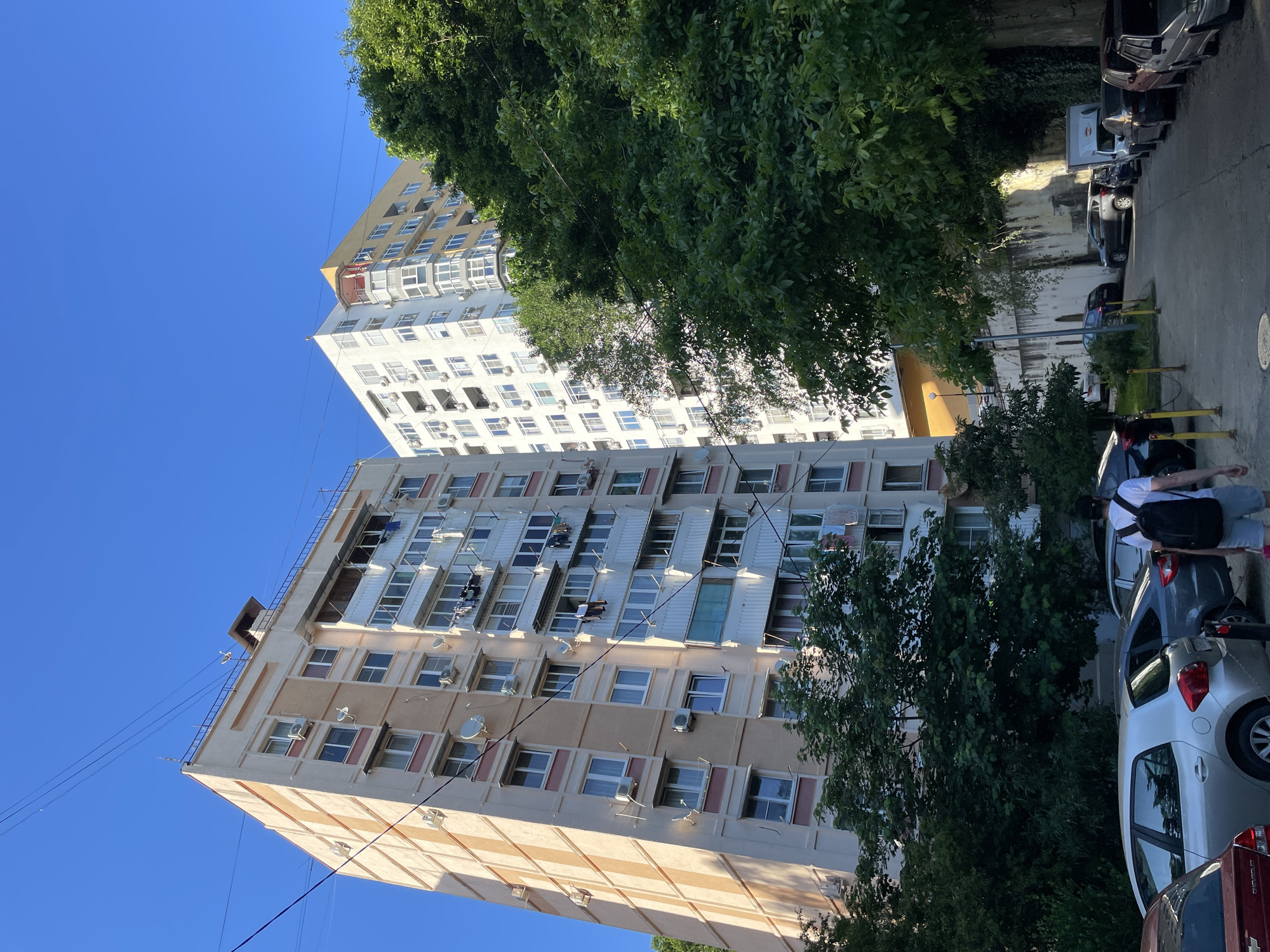 Pedestrian documents residential Sochi neighborhoods in afternoon walkabout