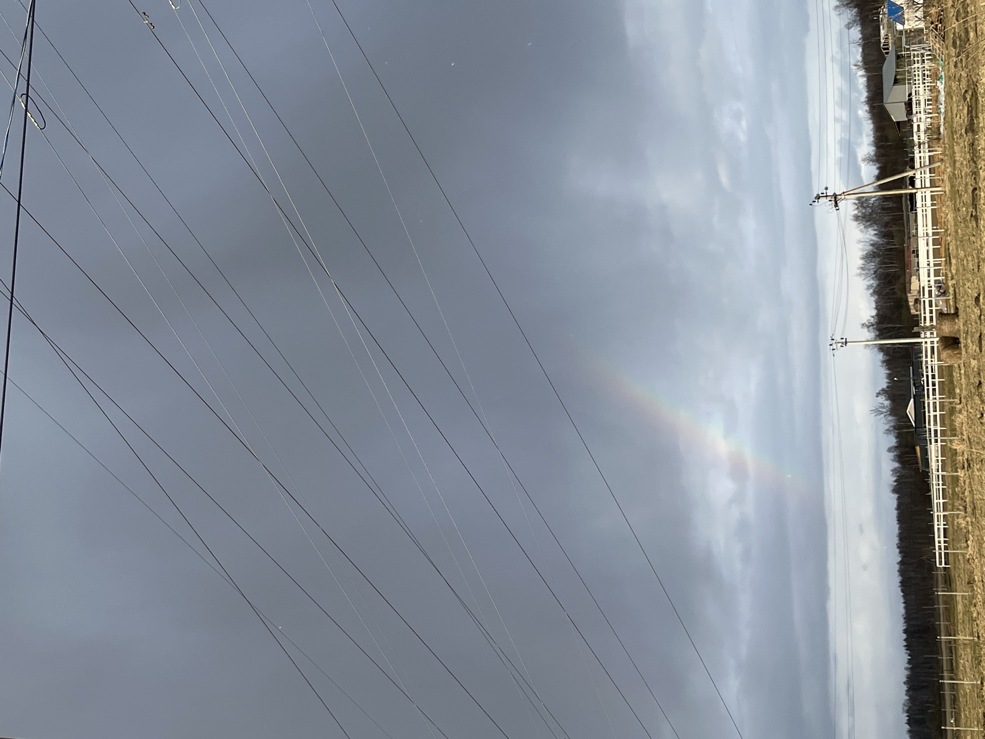Faint rainbow appears over power lines in Razdol'e, Russia