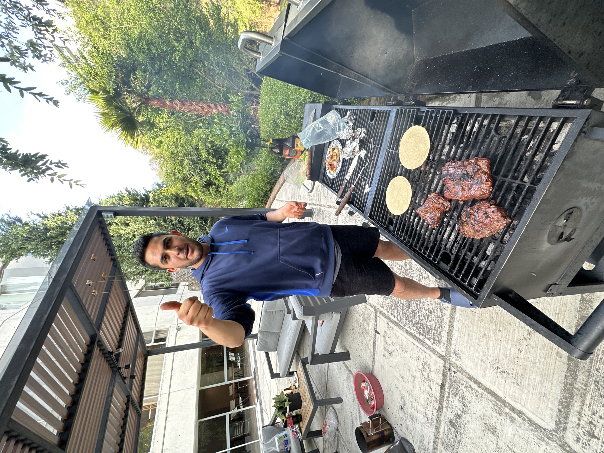 Man grills meat and tortillas outdoors in Mexico
