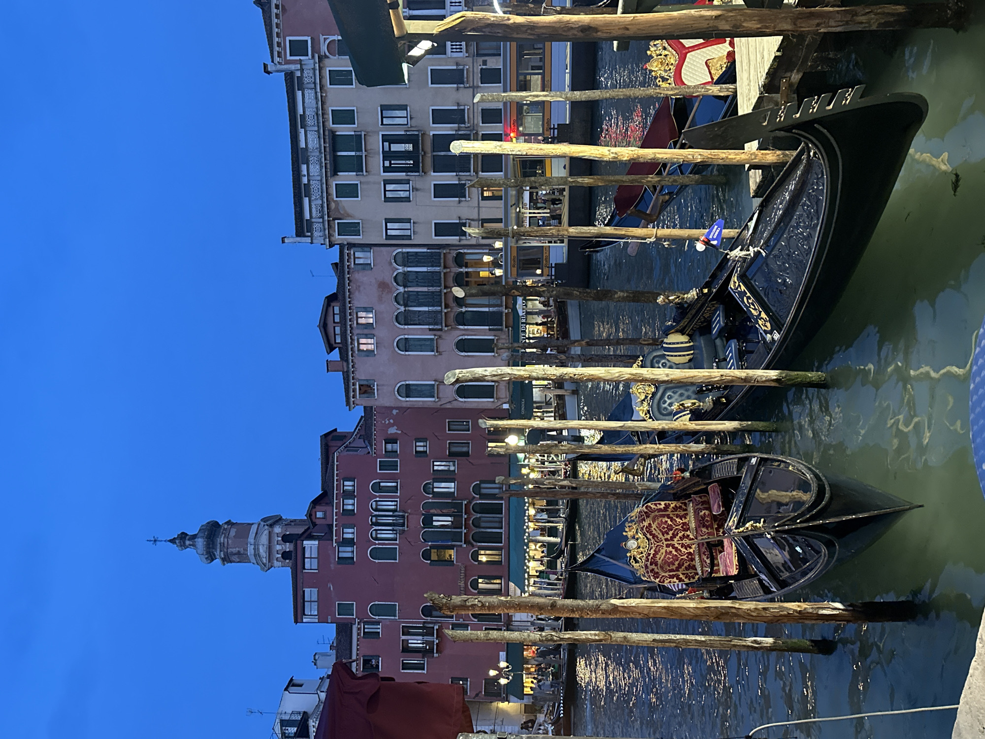 Evening gondolas moored along Venice canal at dusk
