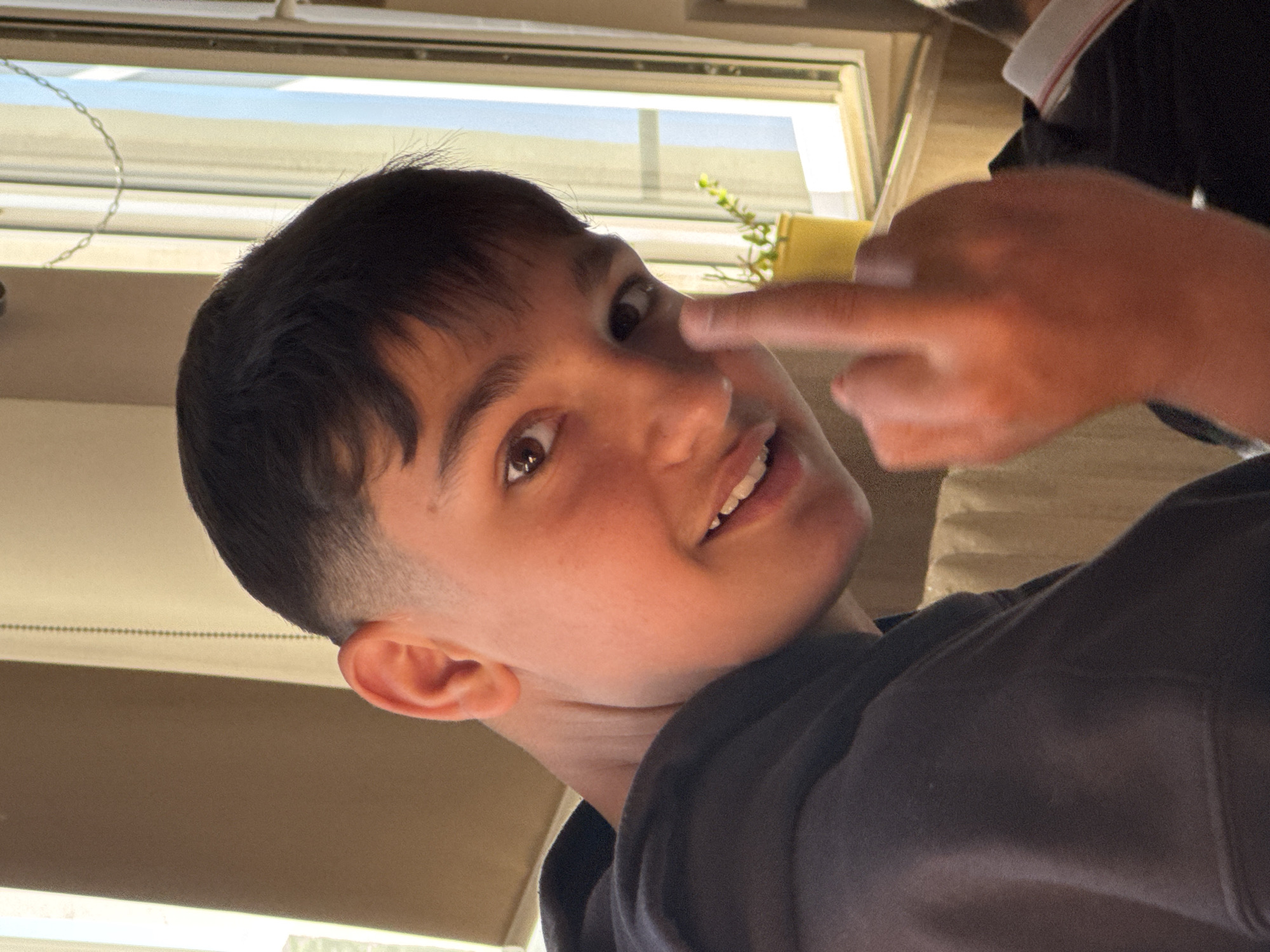 Boy photographed making playful gesture in Pazardzhik home