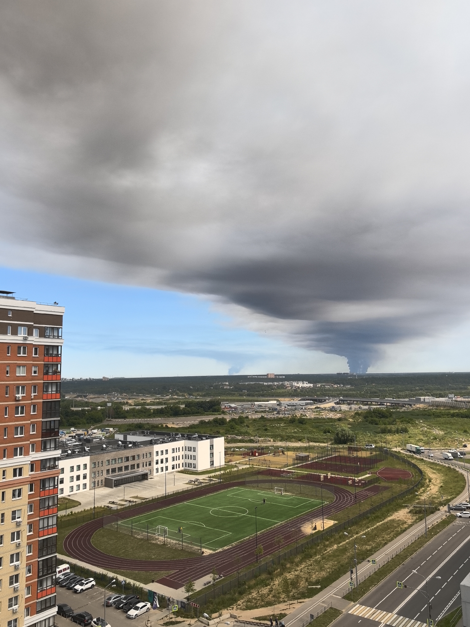 Storm clouds gather over suburban skyline near a brick apartment building