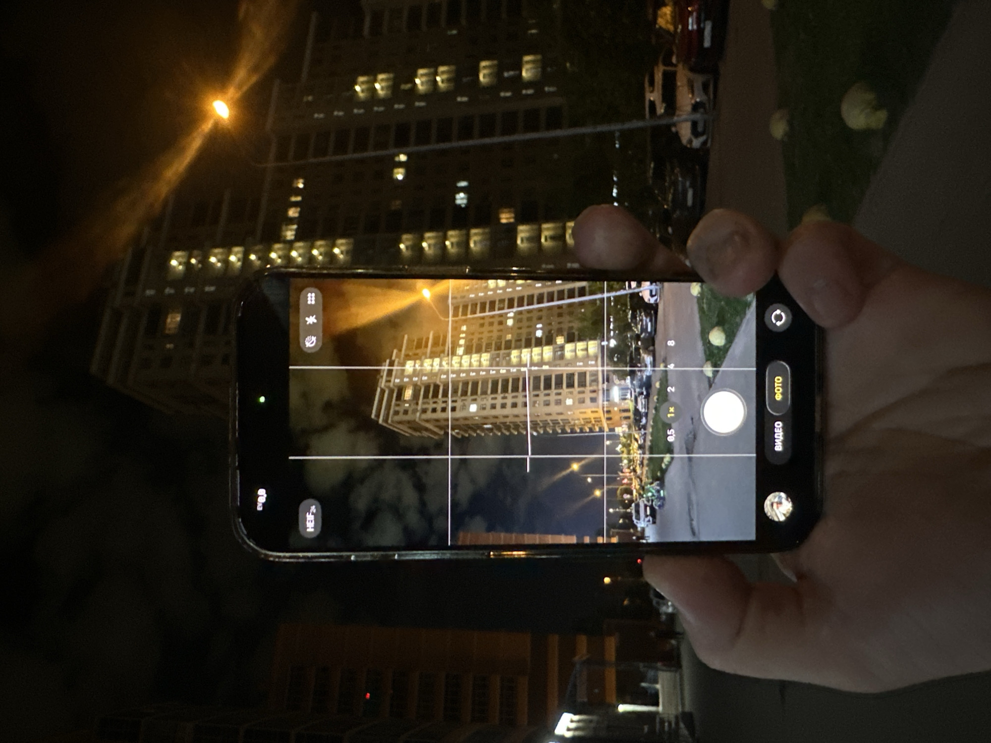 Person photographs apartment building at night in Kazan
