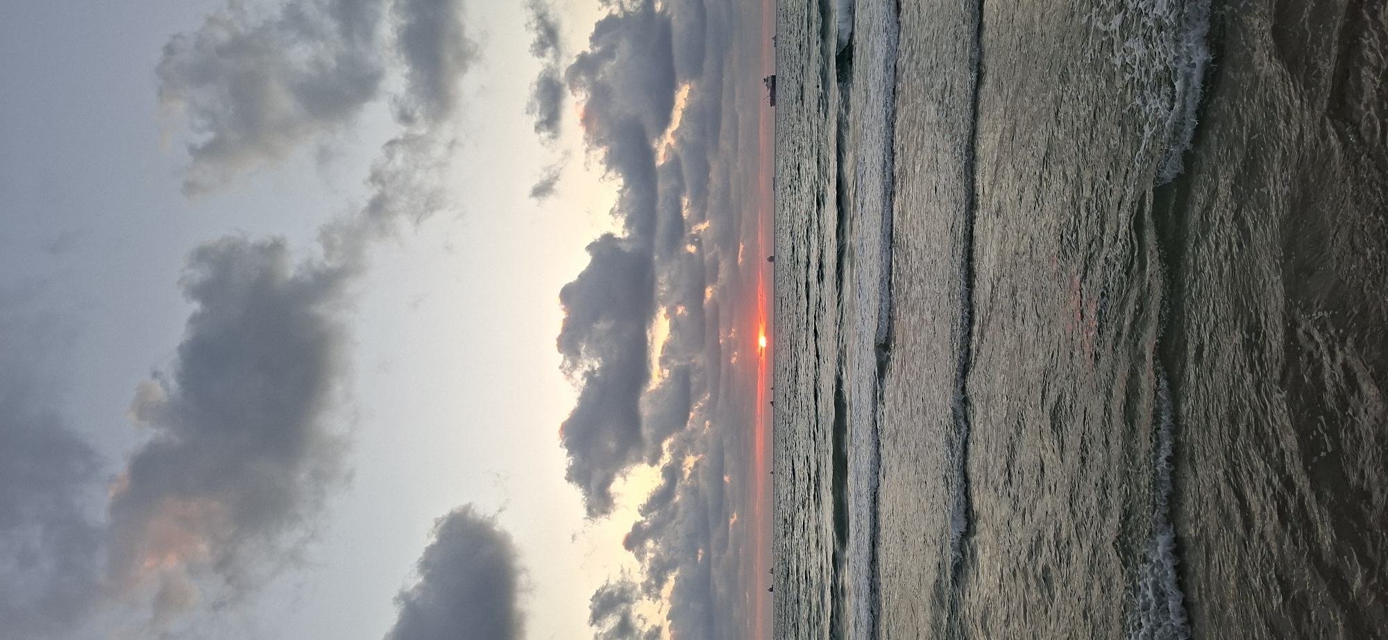 Sunset at the waterfront: waves, fishing rods, and fading light