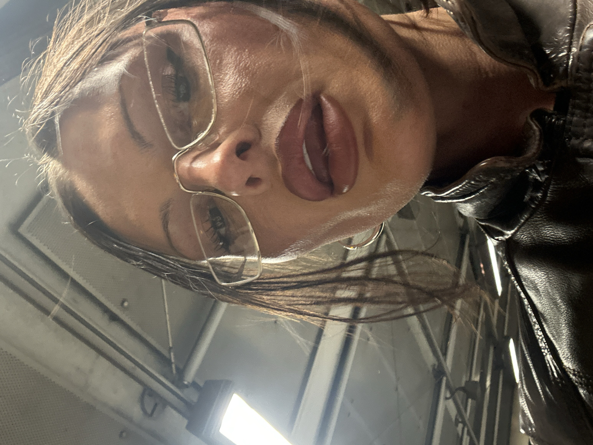 Portrait of glasses-wearing person in leather jacket captured in London
