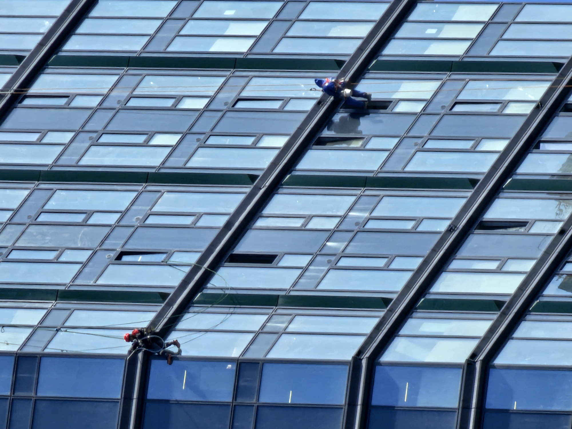 Crews service the glass facade of a Moscow high-rise