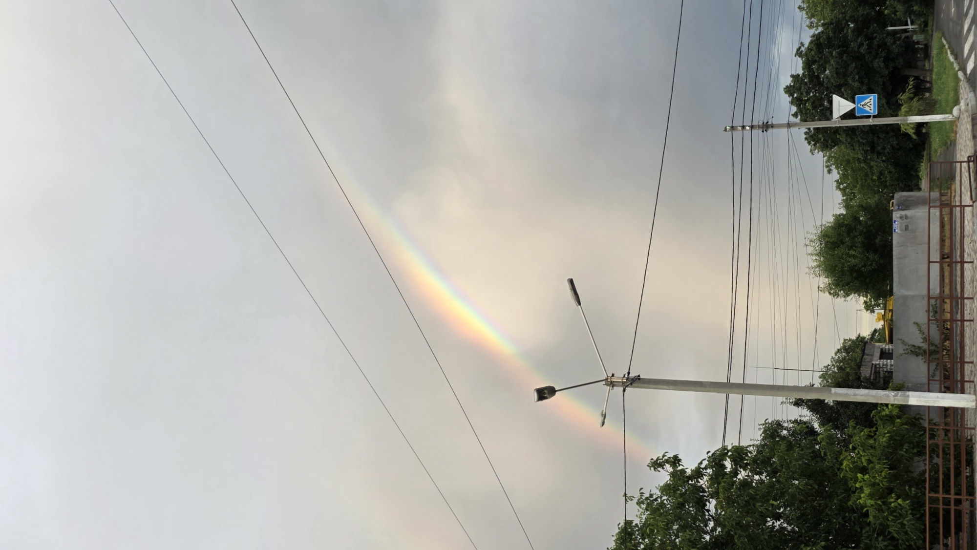 Rainbow over Izmail's cloudy skies, framed by power lines