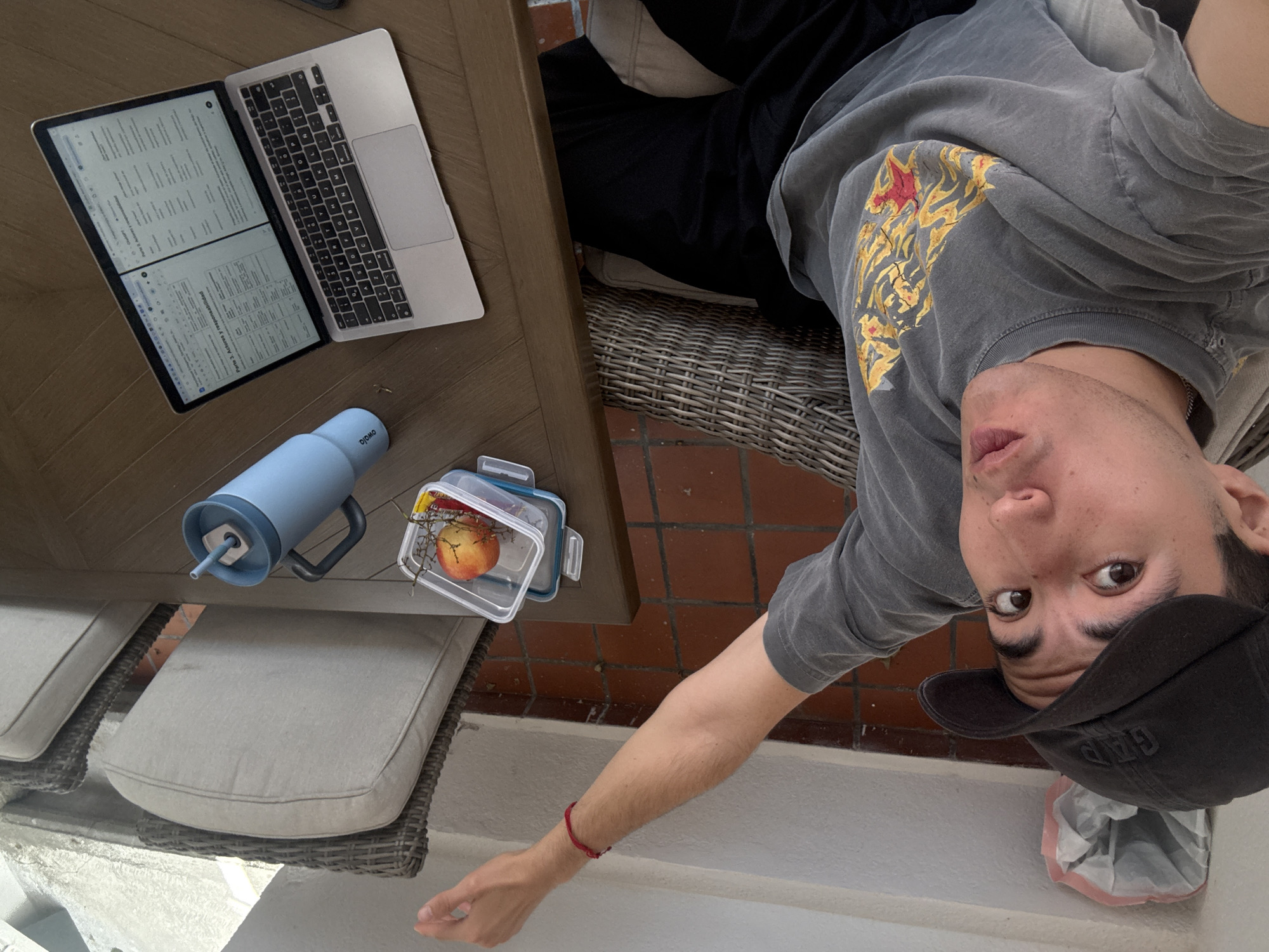 Man observed at outdoor table, later opening candy indoors