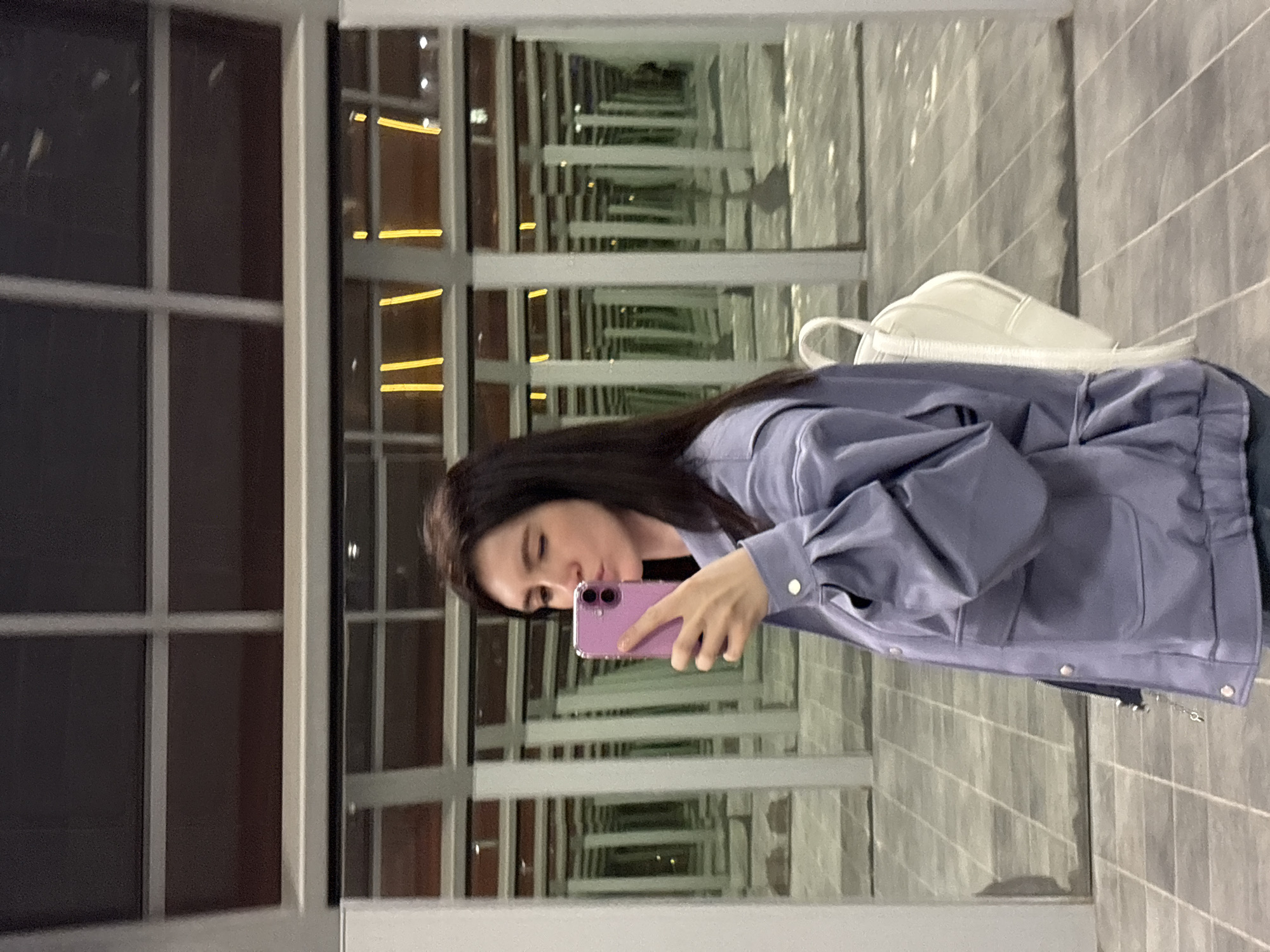 Woman captures selfies in mirrored Moscow spaces near astronaut mural