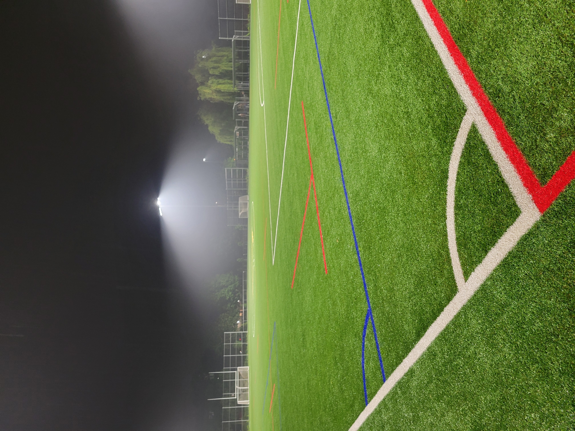 Empty Montreal soccer field glows under stadium lights in the rain