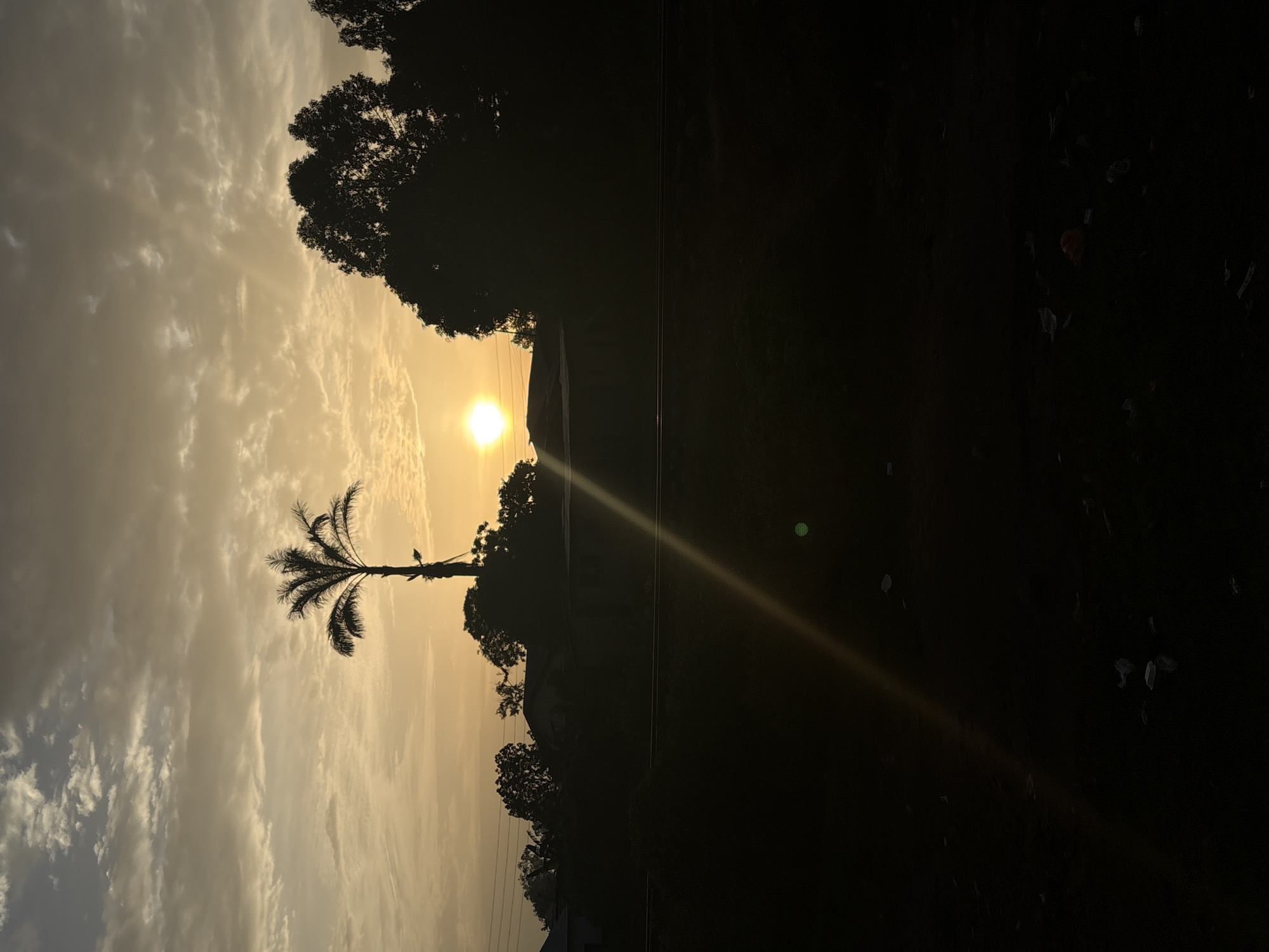 Sunrise breaking over Bukuru's roads and palm trees