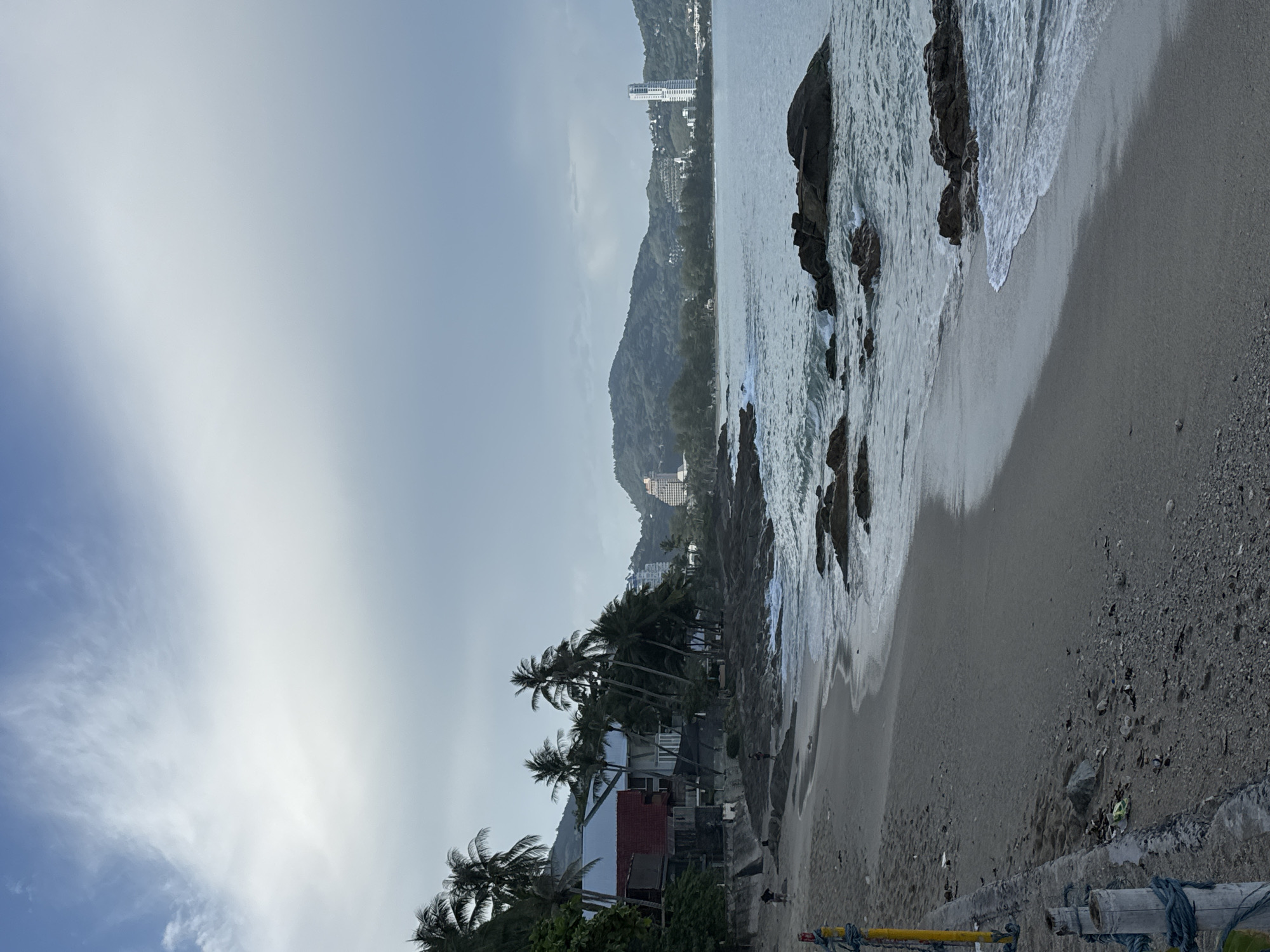 Overcast day at Patong Beach with rocky shores and coastal views